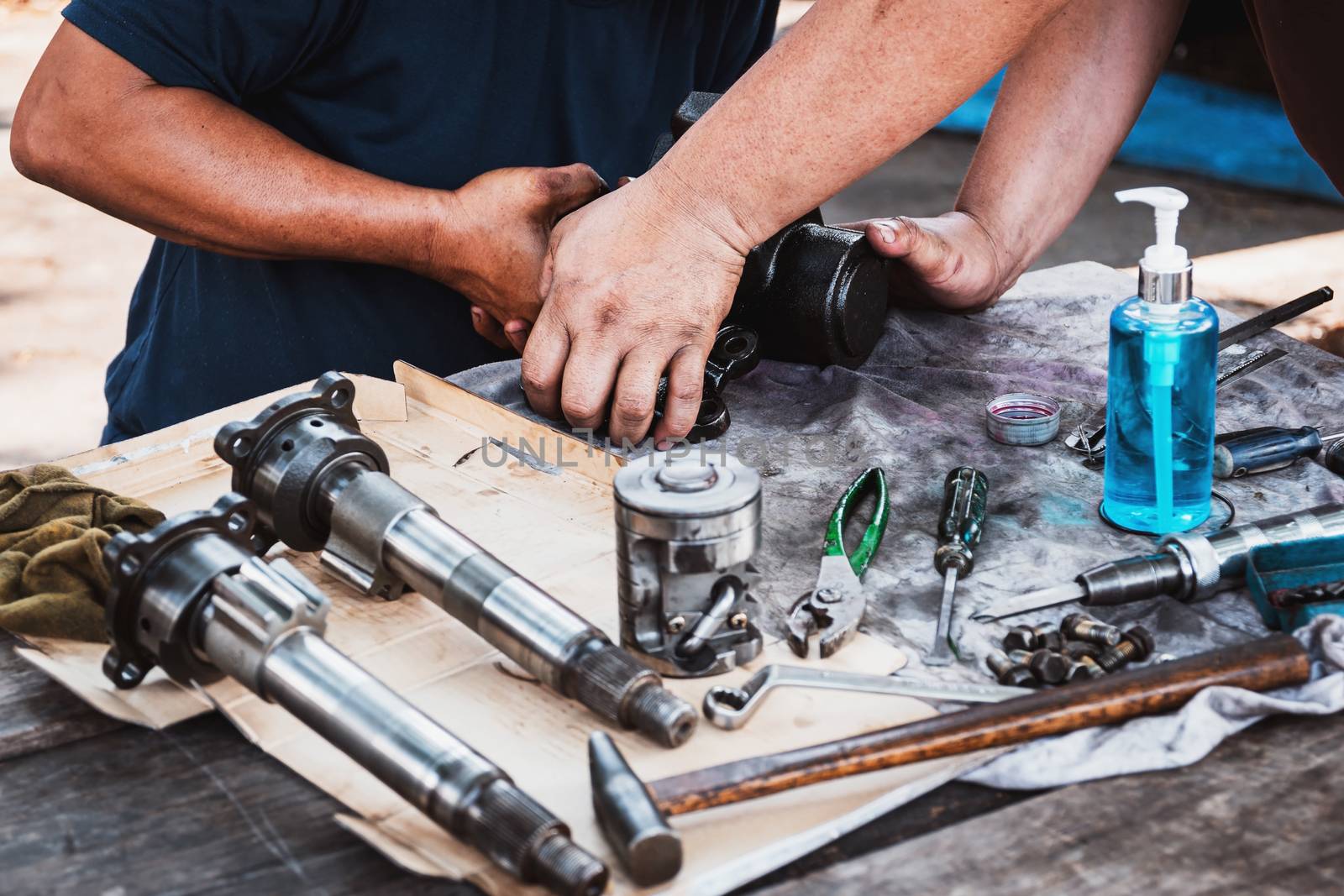 Technicians are helping to assemble the car power steering gearbox.