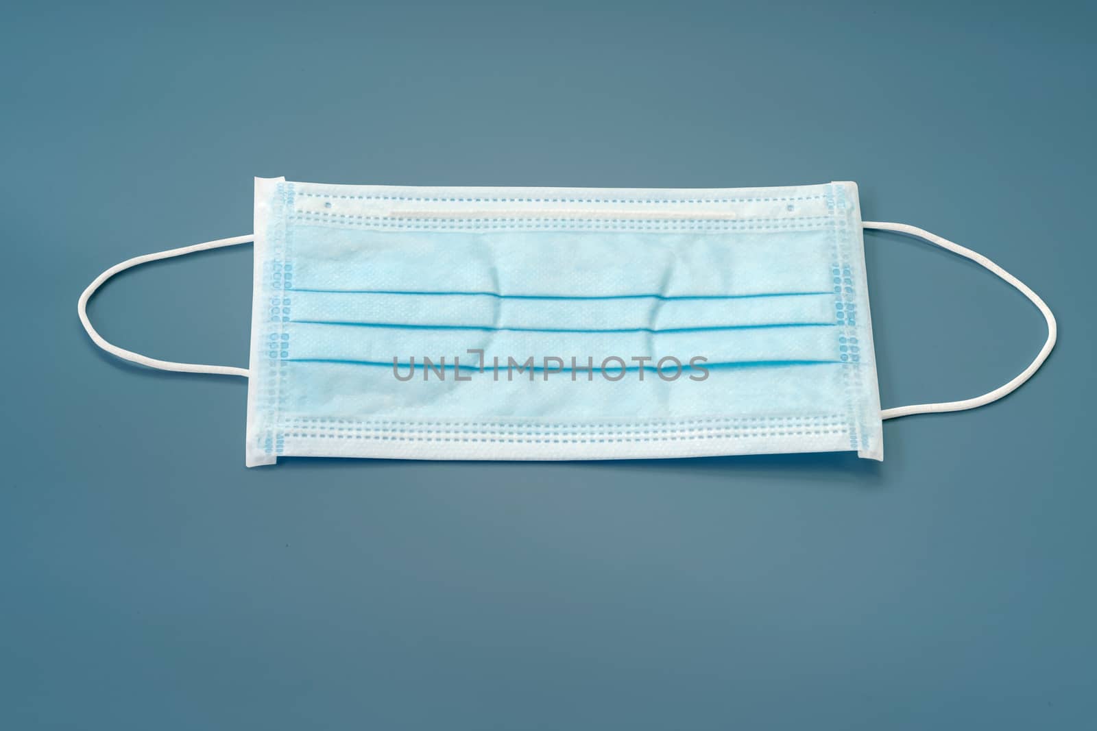 Sanitary napkin mask for preventing spreading and respiratory infections isolated on blue pastel background, Stop Coronavirus Covid-19 concept.