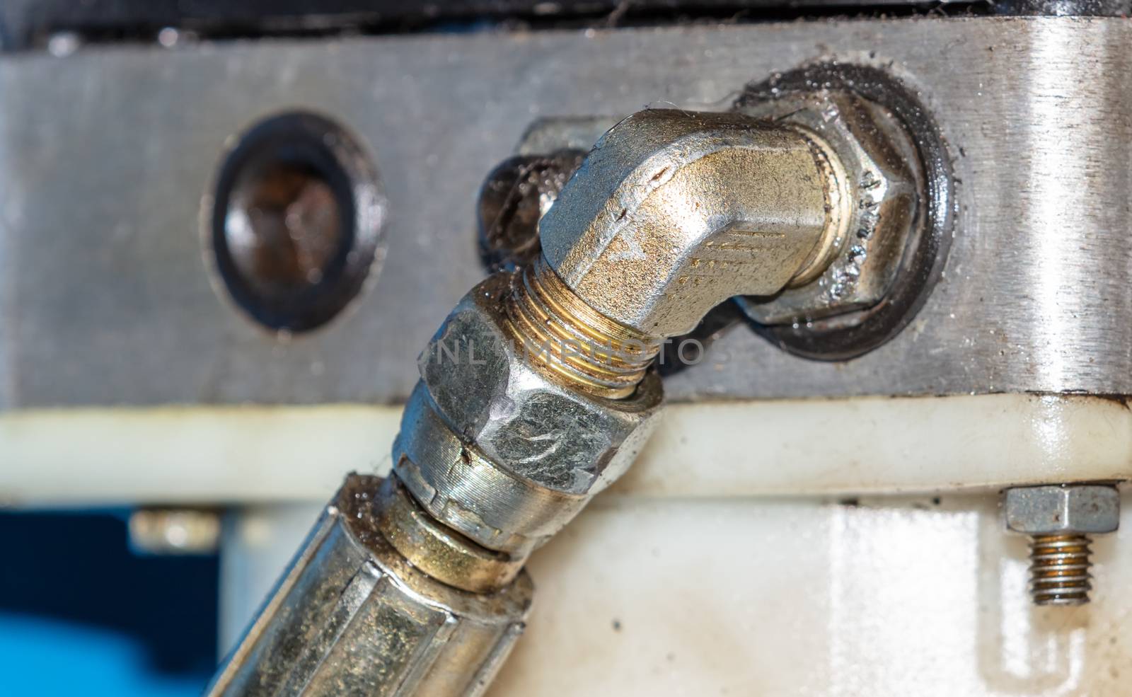 Close up shot of hydraulic pressure hose of a car lifting mechanism in repair shop
