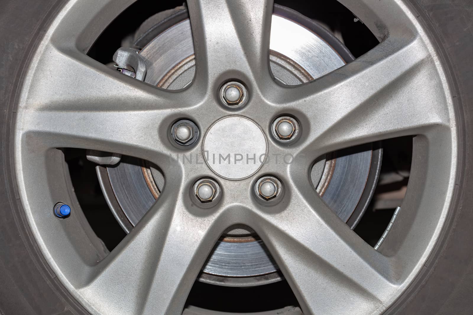 Car wheel on a car close-up, wheel tuning disk and tire in repair workshop