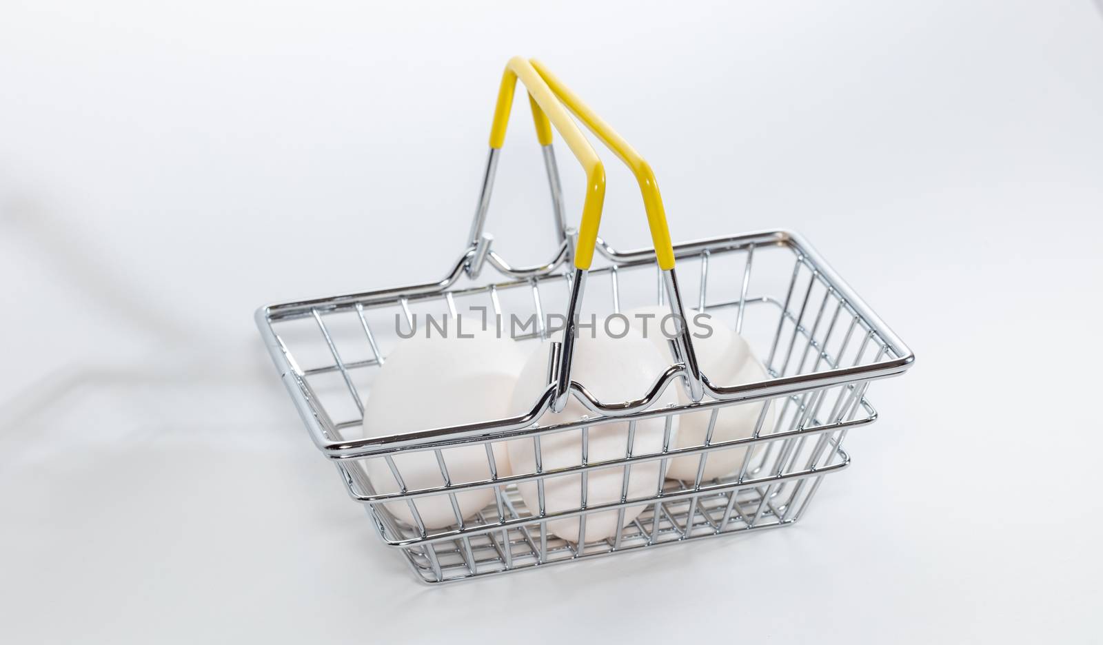 Fresh eggs in a shopping basket. High angle shot. Basket hands up. Shopping, purchasing, and food delivery concept. White background. Close up shot. Isolated.