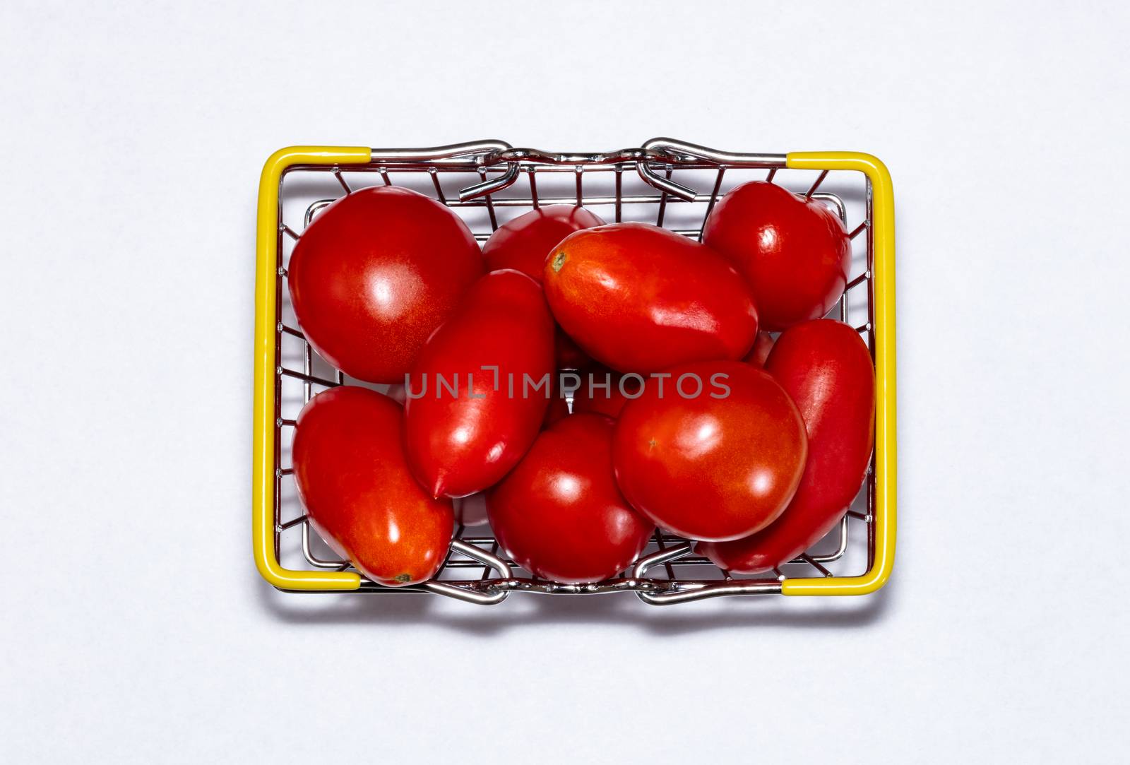Shot of tomatoes in shopping basket isolated on white background. Ripe tasty red tomatos in shopping basket. Top view by DamantisZ