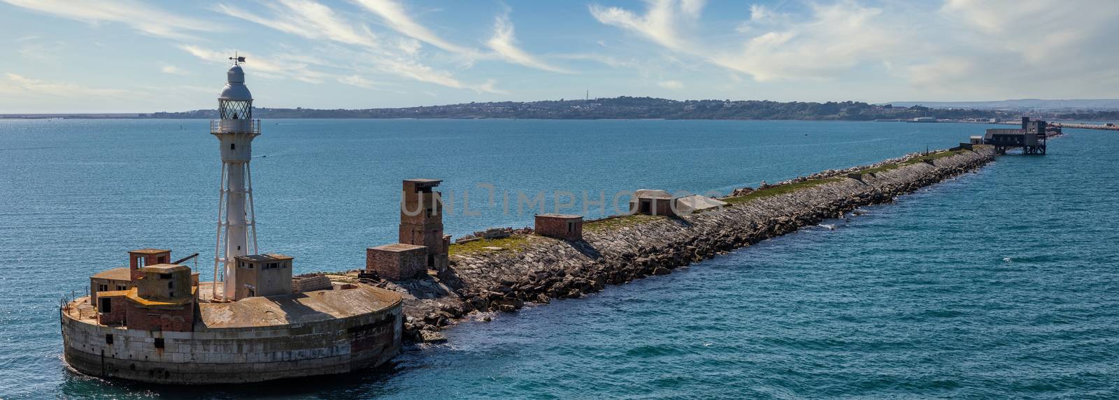 Lighthouse and water barrier at the entrance to the Portland harbour in Weymouth Bay, UK by DamantisZ