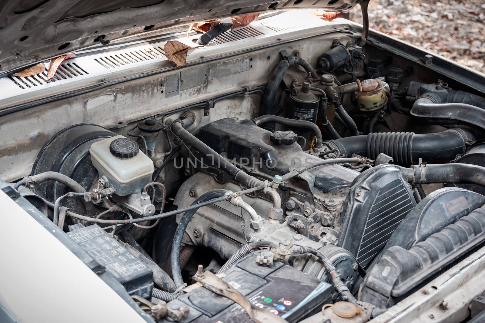 Closeup of the old engine of the car that is parked in the garage to wait for it to be restored to use.