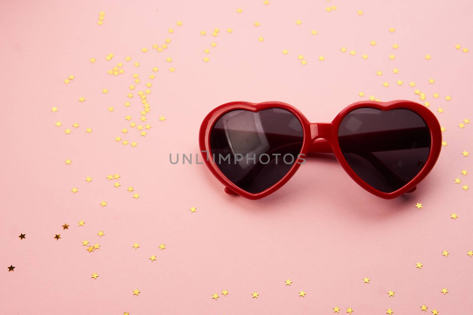 glasses with red frames on a pink background. High quality photo