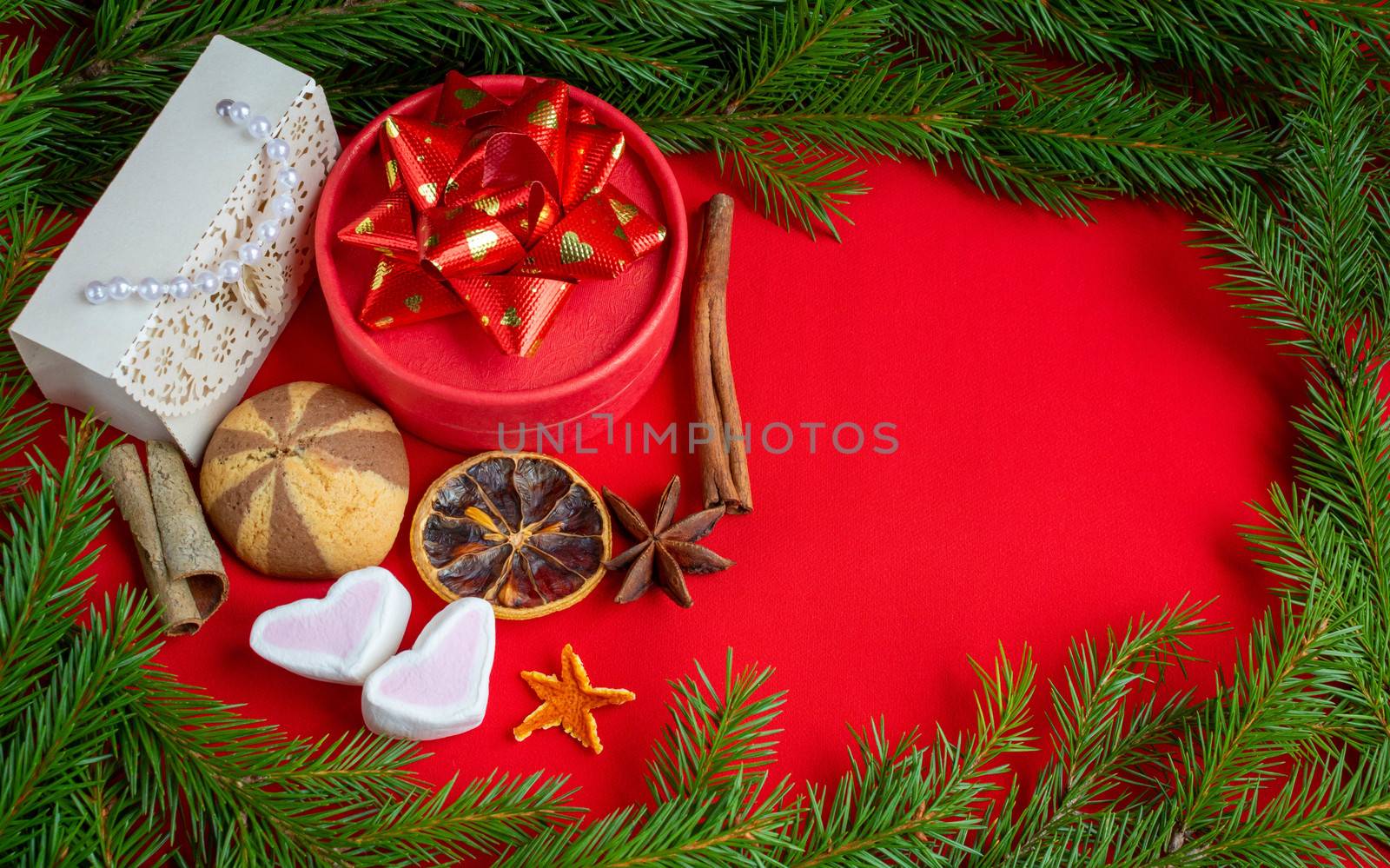 Christmas gifts lie on the background of a spruce branch on a red background. Copy of the space, banner.