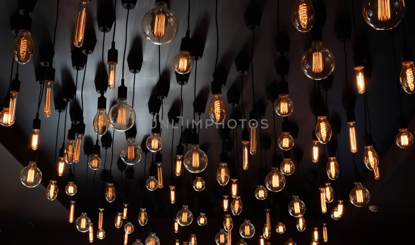 Retro Edison lamp on a black background of the ceiling. Concept idea.