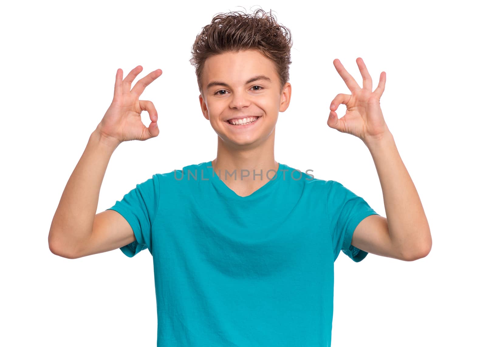 Portrait of handsome teen boy making Ok Gesture. Happy cute child isolated on white background.