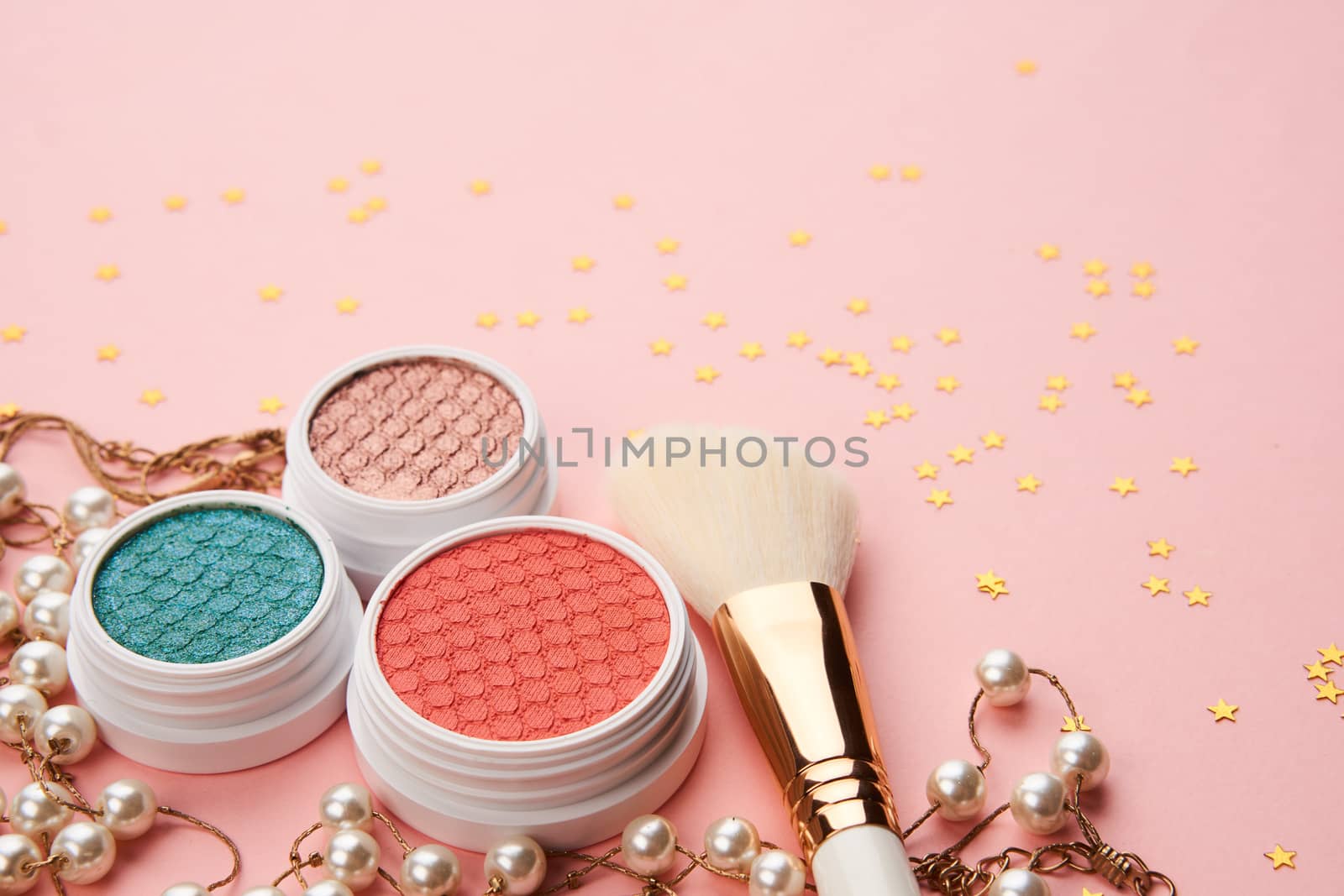 eyeshadow accessories beads makeup brushes collection professional cosmetics on pink background by SHOTPRIME