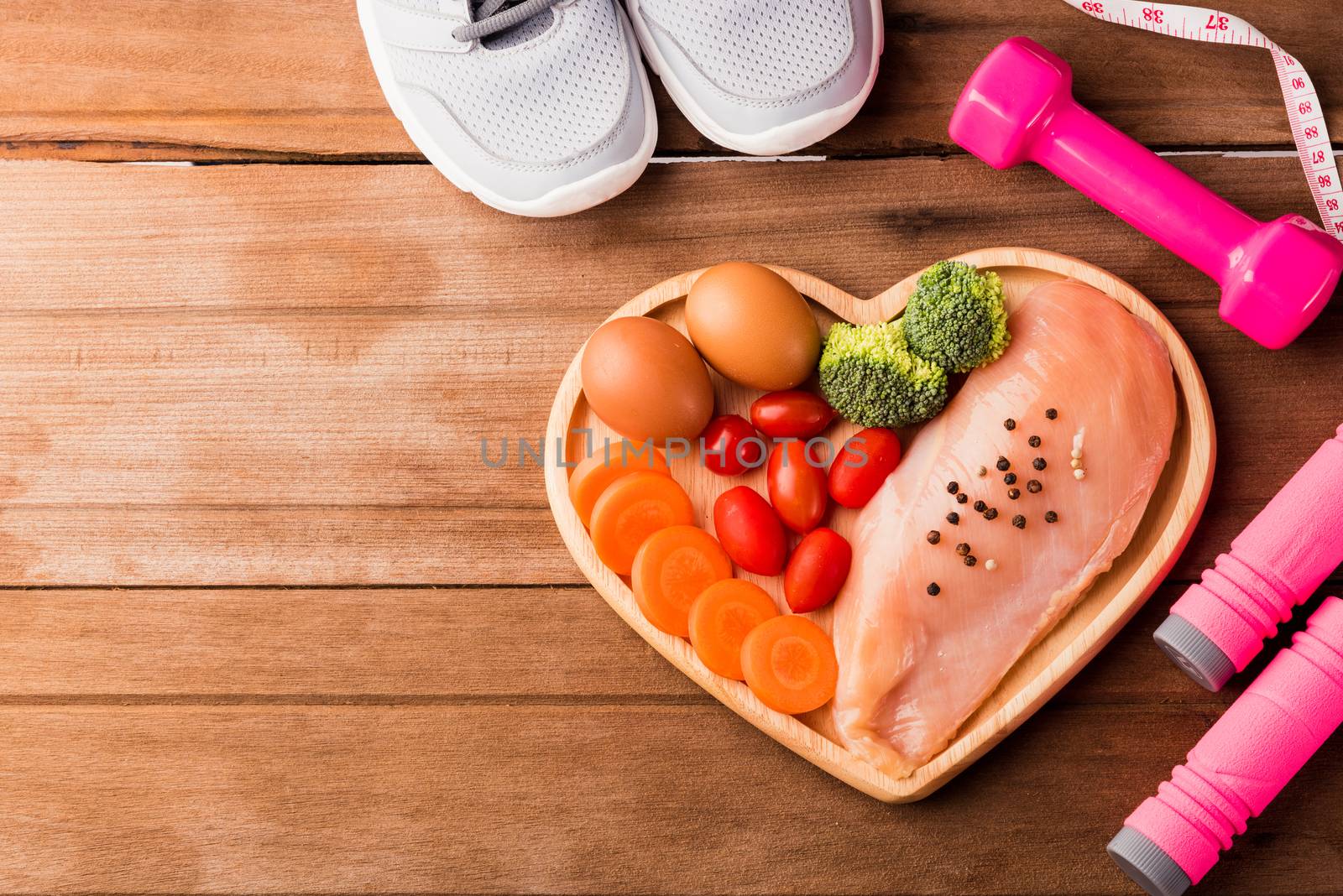 Top view of Raw chicken breasts fillets no boneless with spices in heart plate wood and sport or athlete's equipment dumbbell
running shoes on wooden background, Healthy lifestyle diet food concept