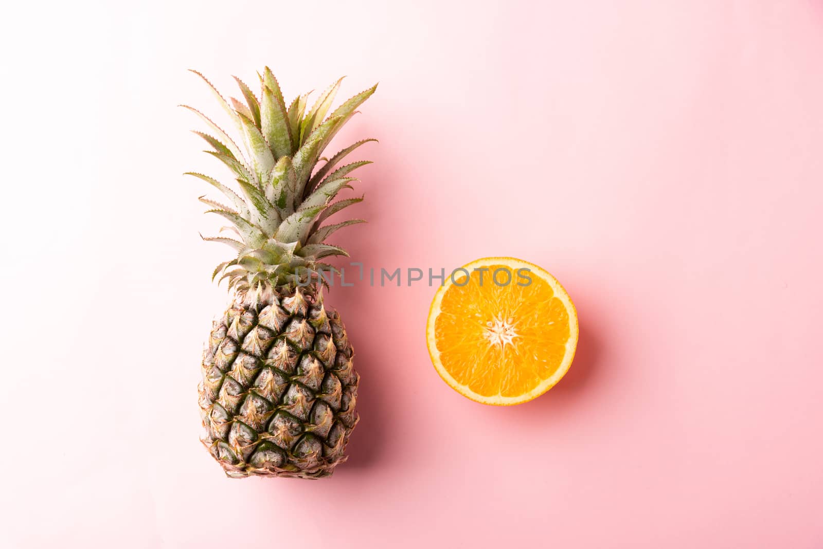 Close up above top view of ripe pineapple and orange fruit on pink pastel background, Summer Tropical, Healthy lifestyle diet food concept