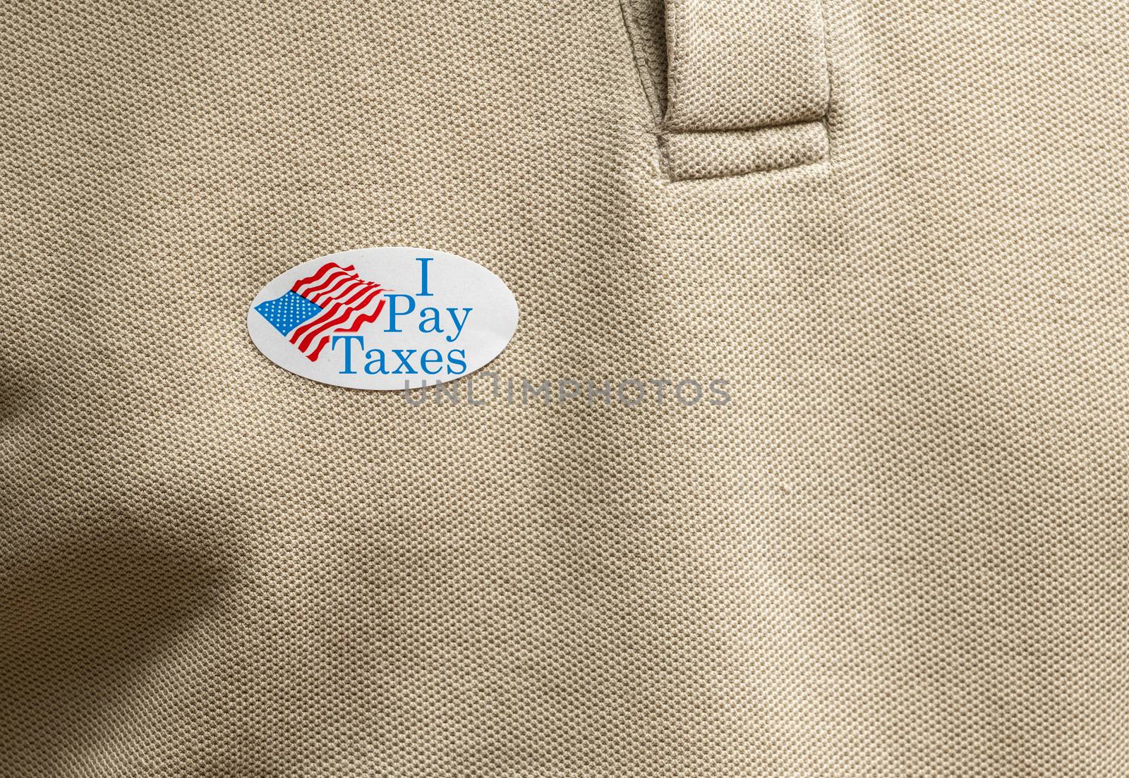 I Pay Taxes sticker on mans T-shirt for anger about the lack of federal tax paid by president in the presidential election