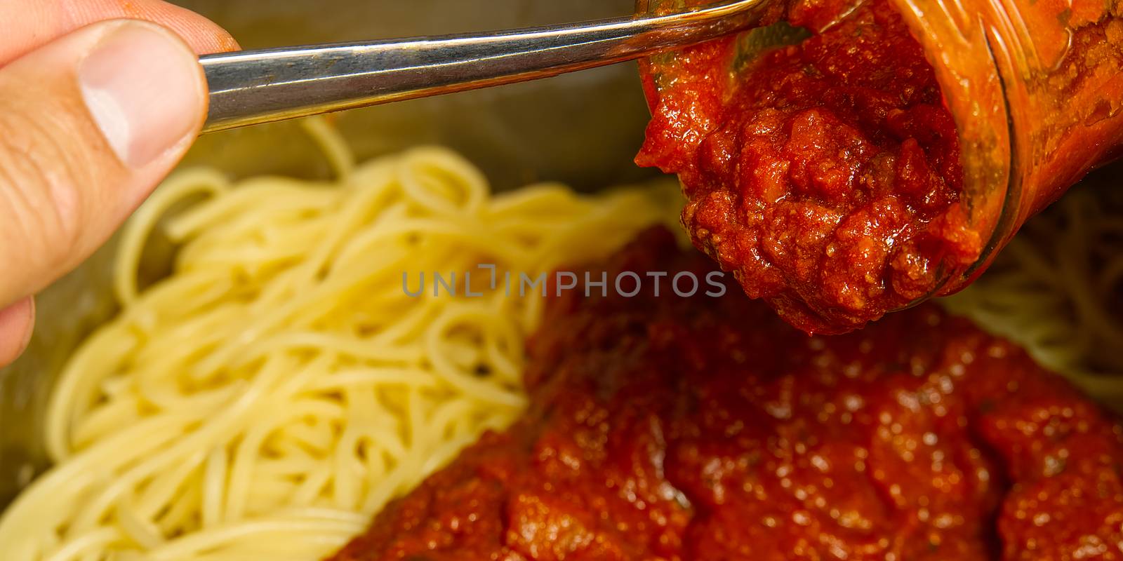 Add bolognese sauce on spaghetti in pot. cooking pasta bolognese at home by PhotoTime