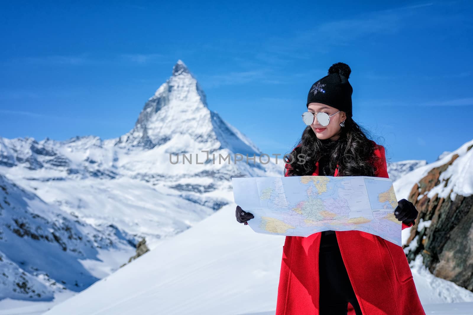 Young female tourist looking map at Matterhorn in Switzerland wi by Surasak