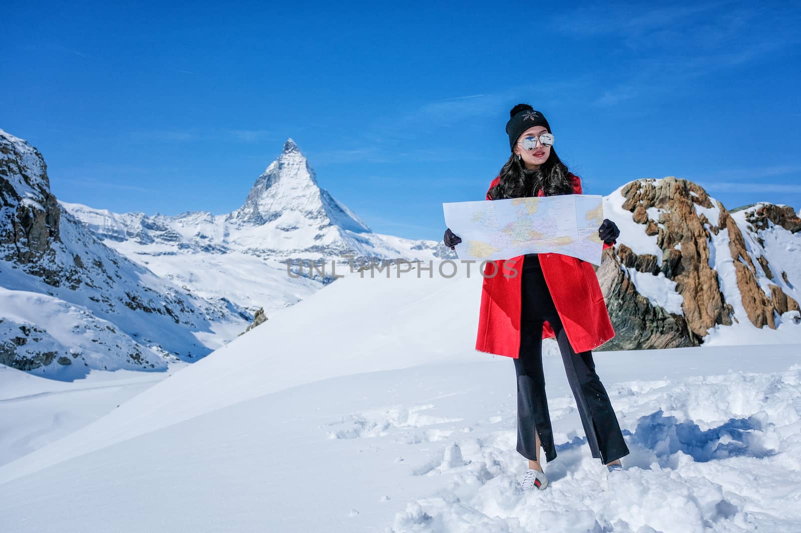 Young female tourist looking map at Matterhorn in Switzerland wi by Surasak