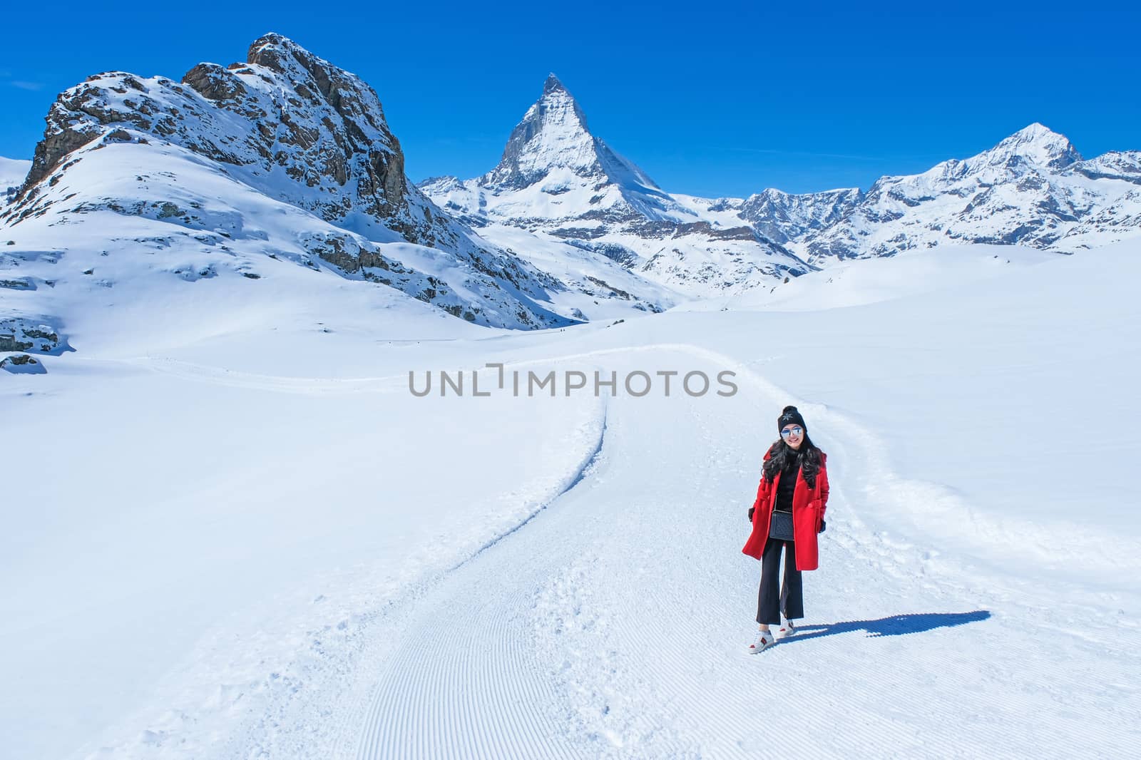 Young Woman Tourists see beautiful view of snow mountain Matterhorn peak, Zermatt, Switzerland.