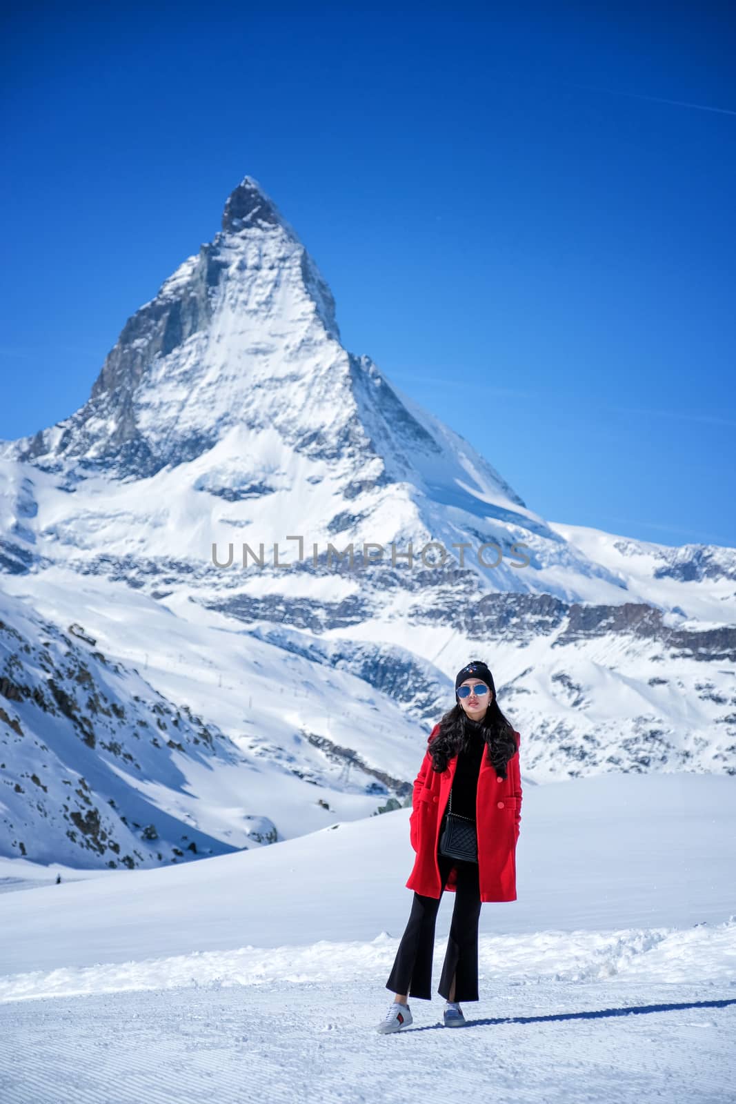 Young Woman Tourists see beautiful view of snow mountain Matterhorn peak, Zermatt, Switzerland.