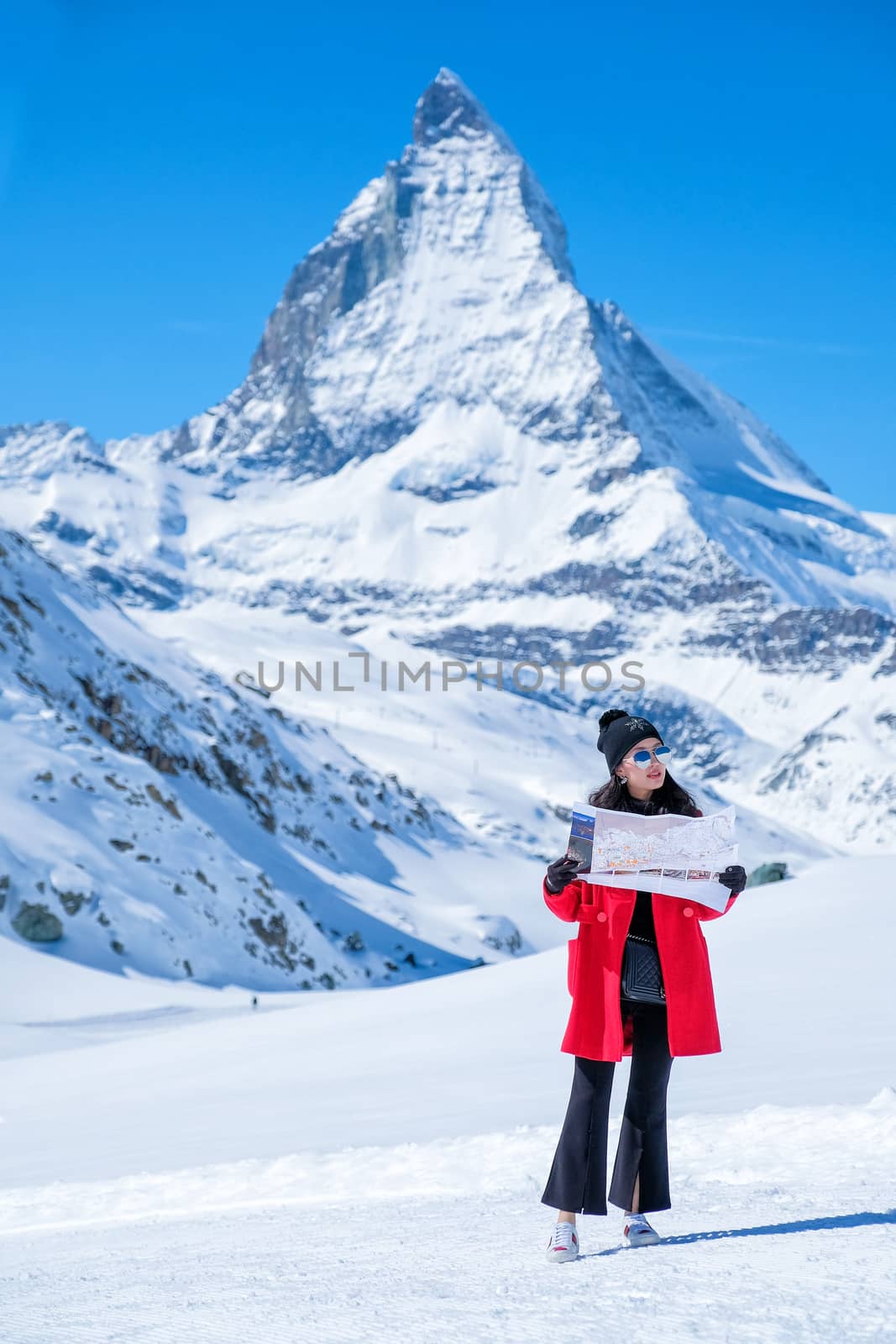 Young female tourist looking map at Matterhorn in Switzerland wi by Surasak