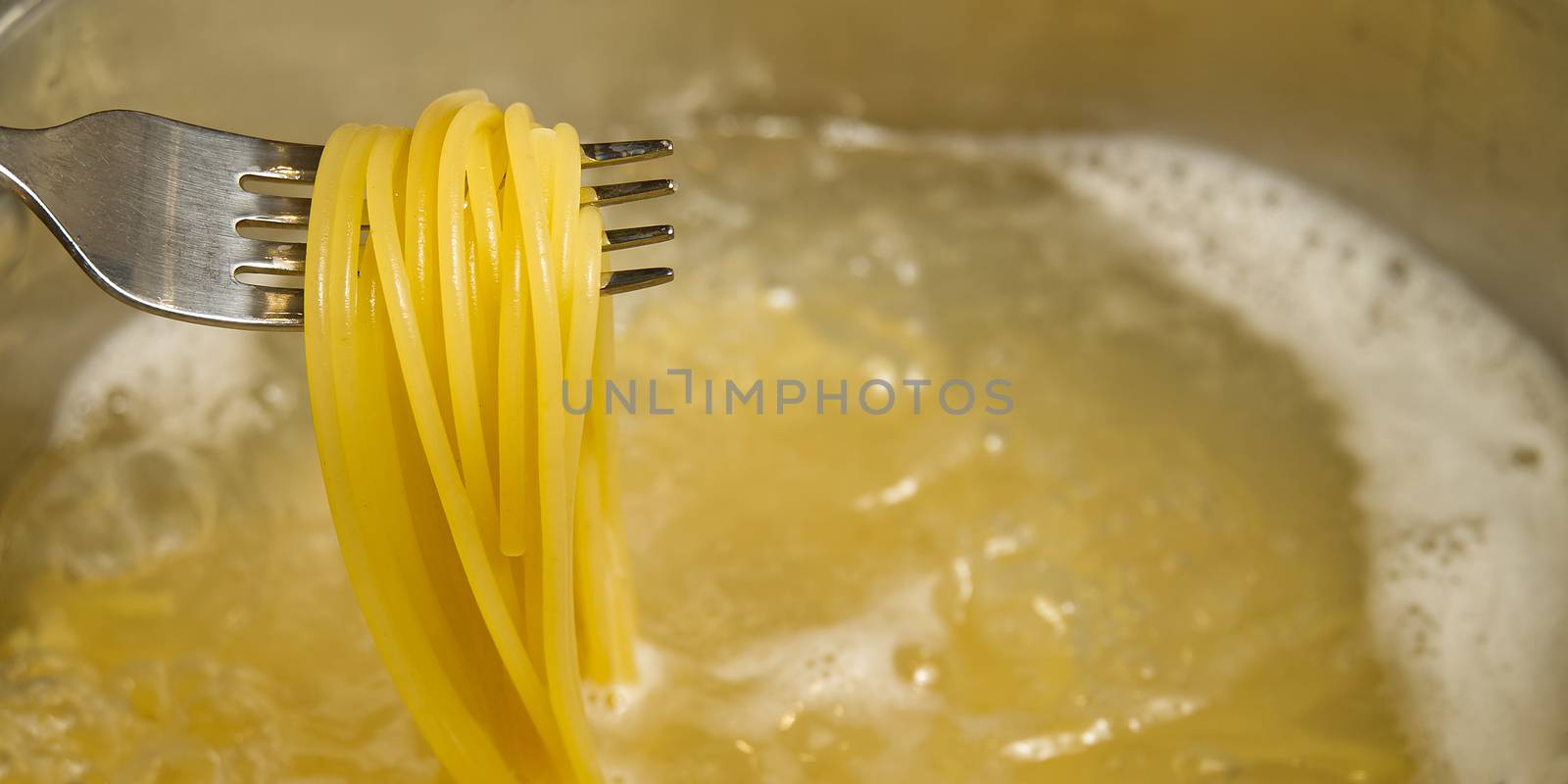 boiling pasta spaghetti in pot. penne rigate pasta- Cooking pasta in boiling water. by PhotoTime