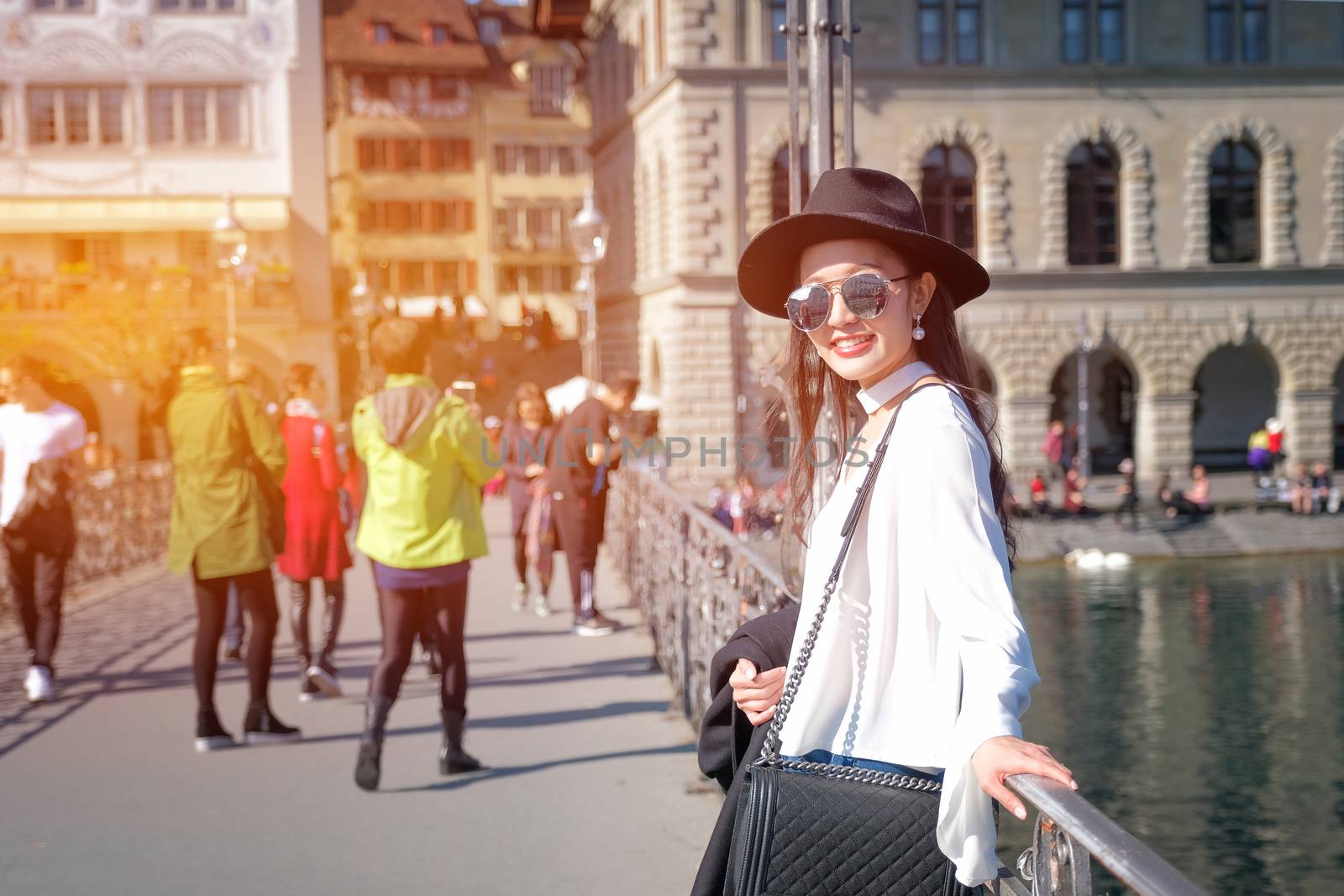 Young female traveler in front of the famous wooden bridge in Lucerne city in Switzerland