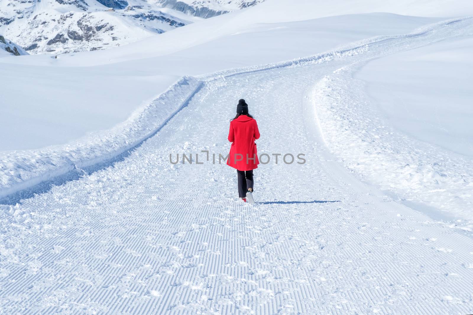 Young Woman Tourist walking in snow mountain Matterhorn peak, Zermatt, Switzerland.