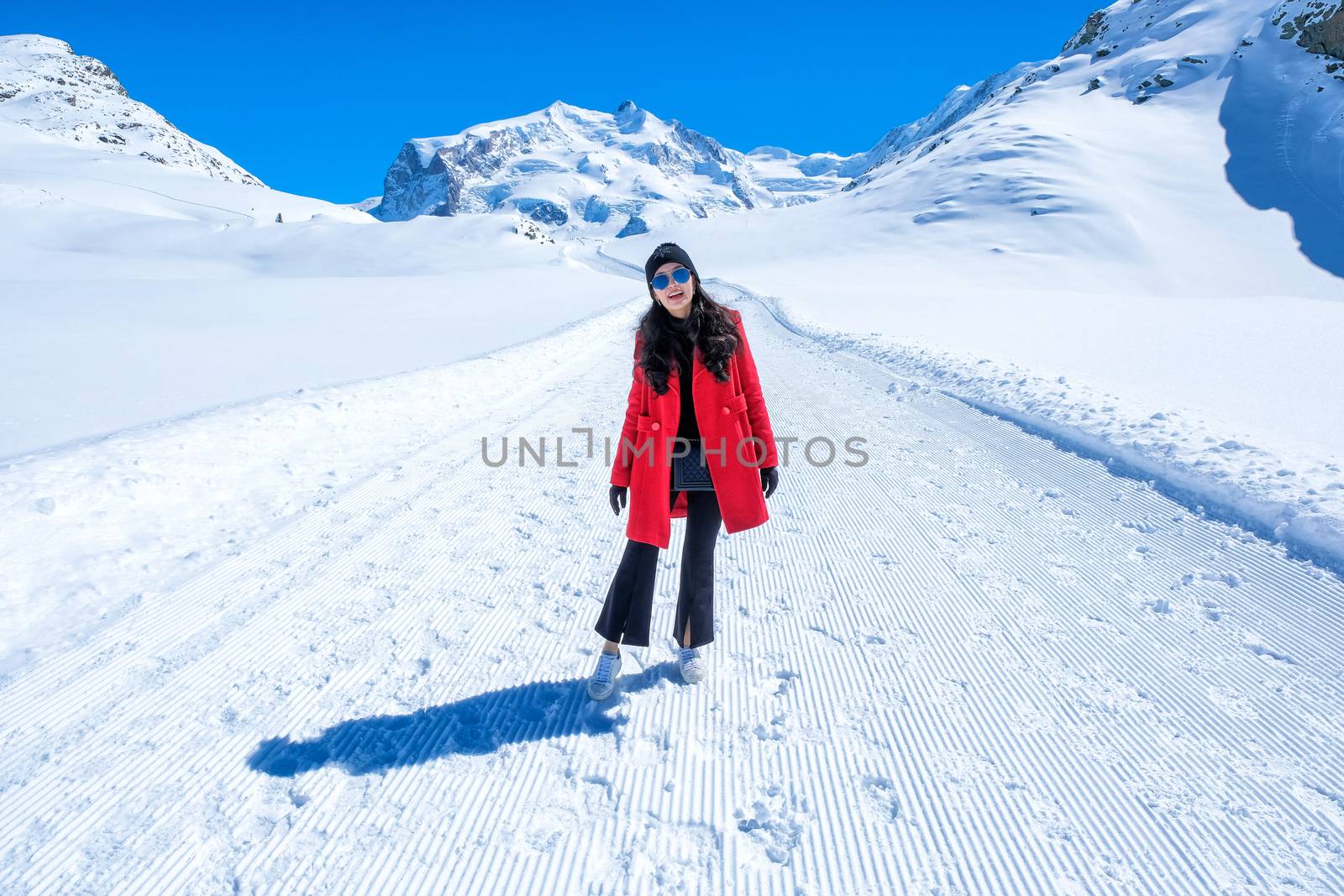 Young Woman Tourist walking in snow mountain Matterhorn peak, Ze by Surasak