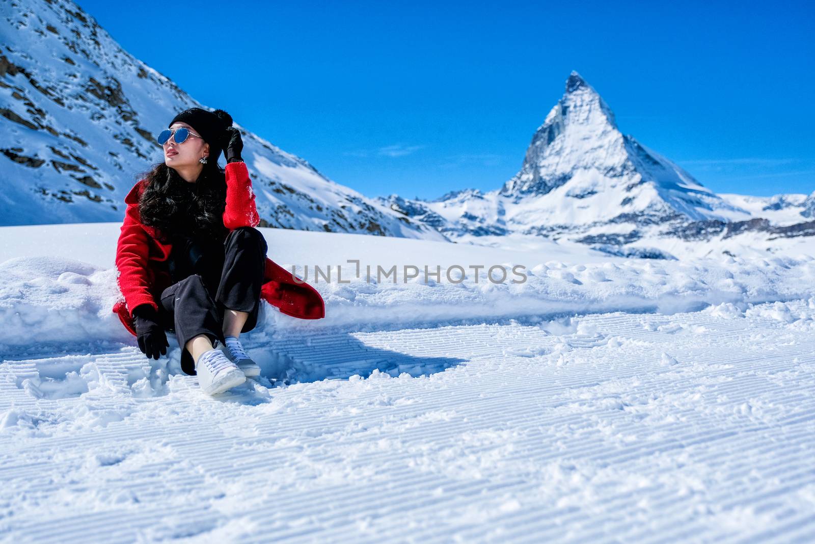 Young Woman Tourists playing snow in mountain Matterhorn peak, Zermatt, Switzerland.