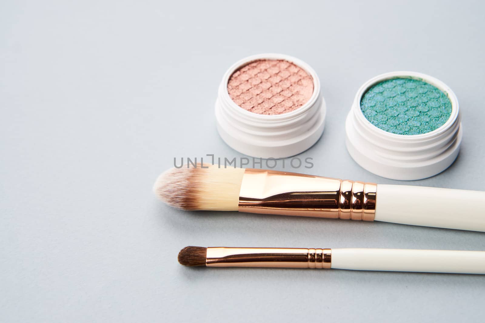 eyeshadow makeup brushes collection professional cosmetics accessories beads on gray background. High quality photo