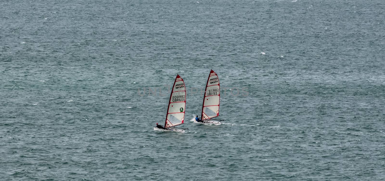 Portland Harbor, UK - July 1, 2020: Two racing Musto Skiff boats sailing in the harbor.