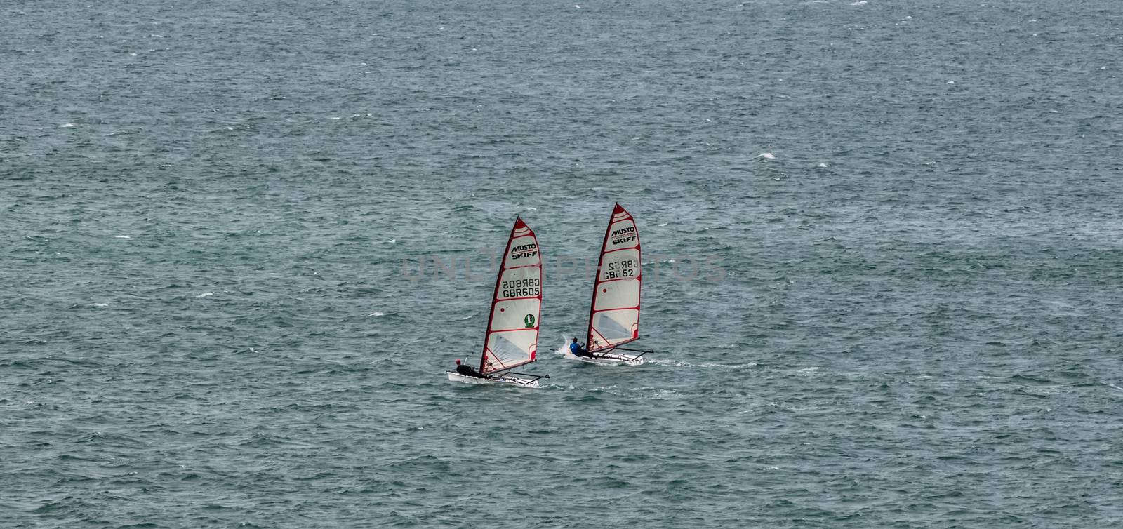 Portland Harbor, UK - July 1, 2020: Two racing Musto Skiff boats sailing in the harbor.