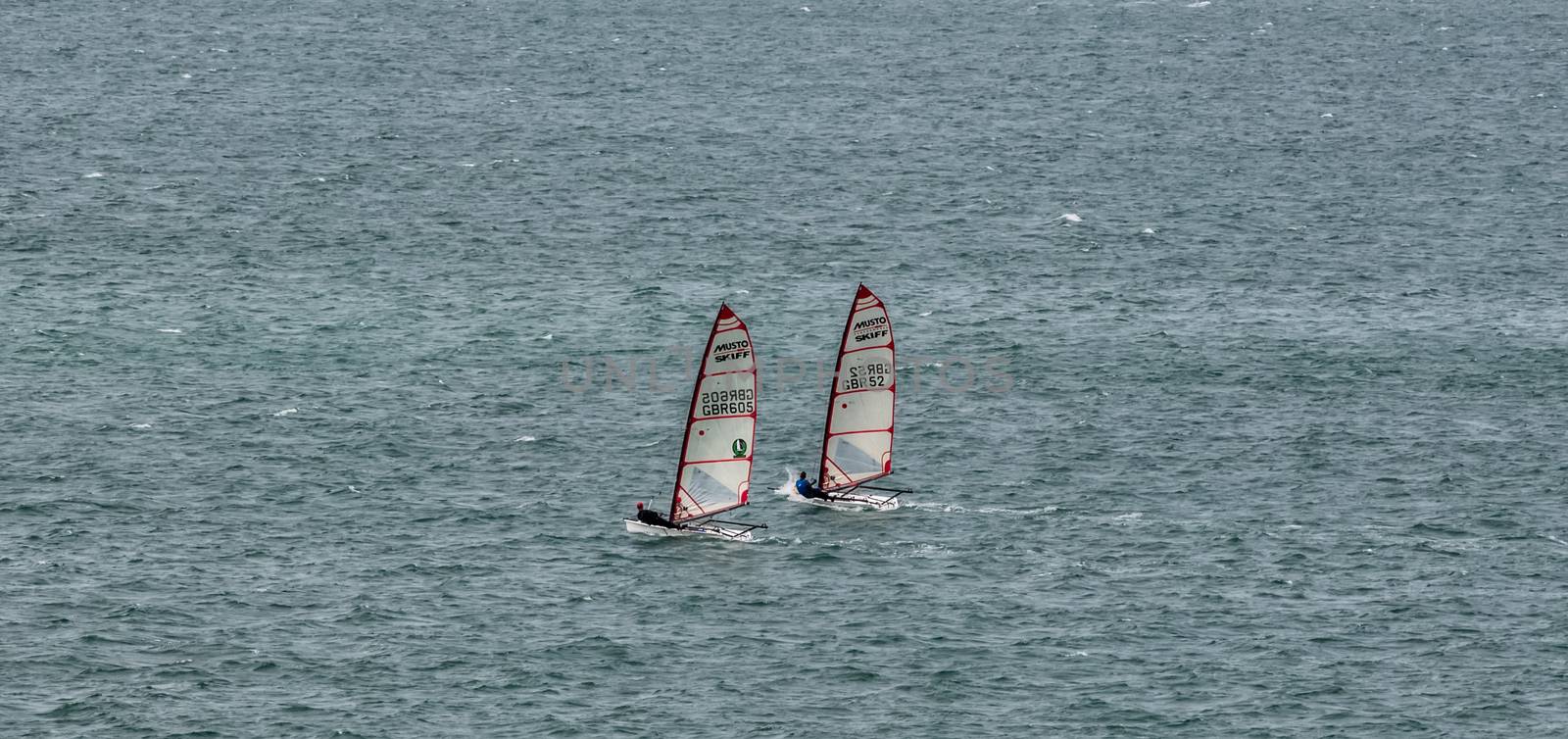 Portland Harbor, UK - July 1, 2020: Two racing boats sailing in the harbor. by DamantisZ