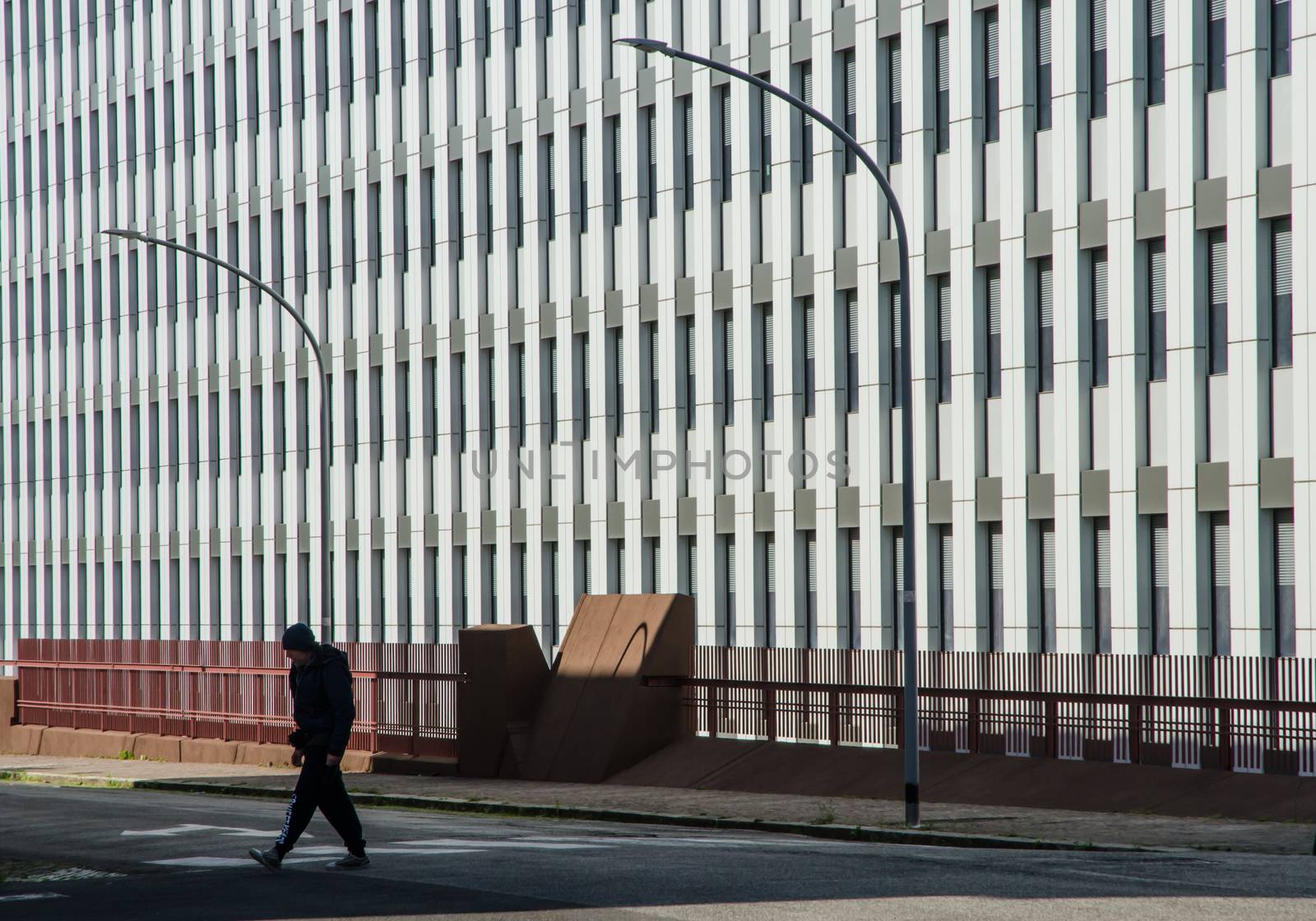 A lonely man crosses the street early Sunday morning, in the shadow of a closed office building