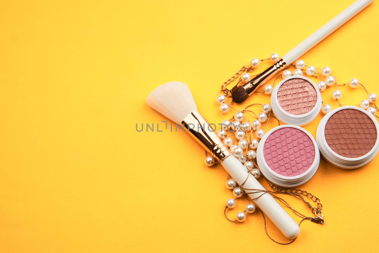 Eyeshadow eye makeup brush on yellow background top view Copy Space. High quality photo