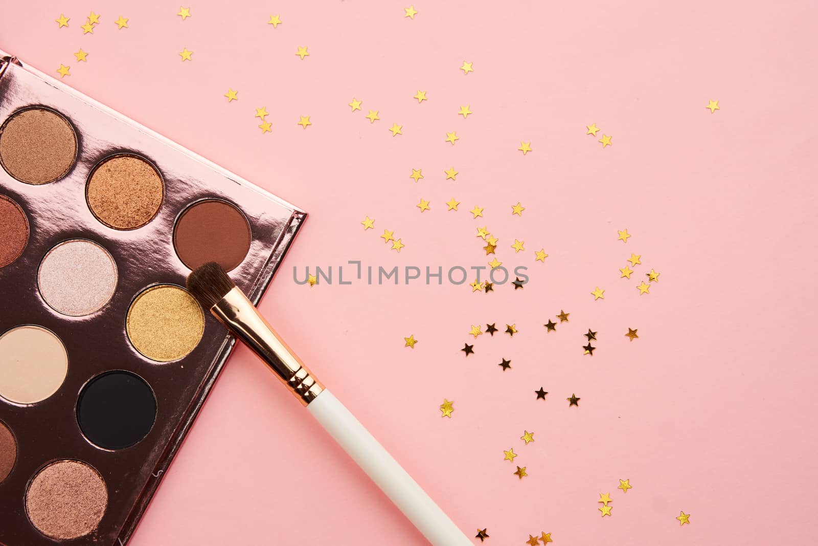 Eyeshadows and makeup brushes on a pink background Copy Space top view by SHOTPRIME
