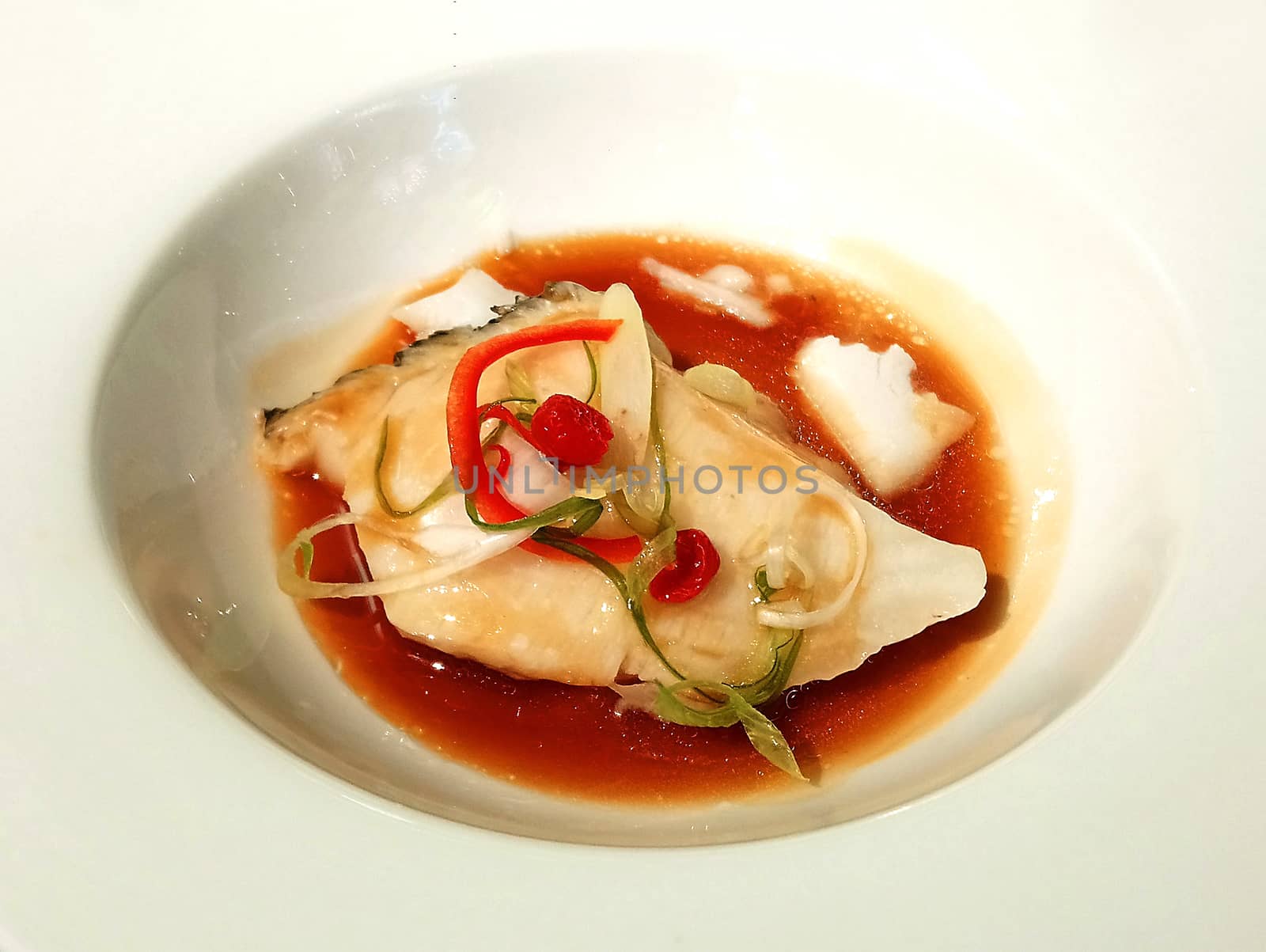 Steam fish with sauce on white bowl serve in hotel restaurant