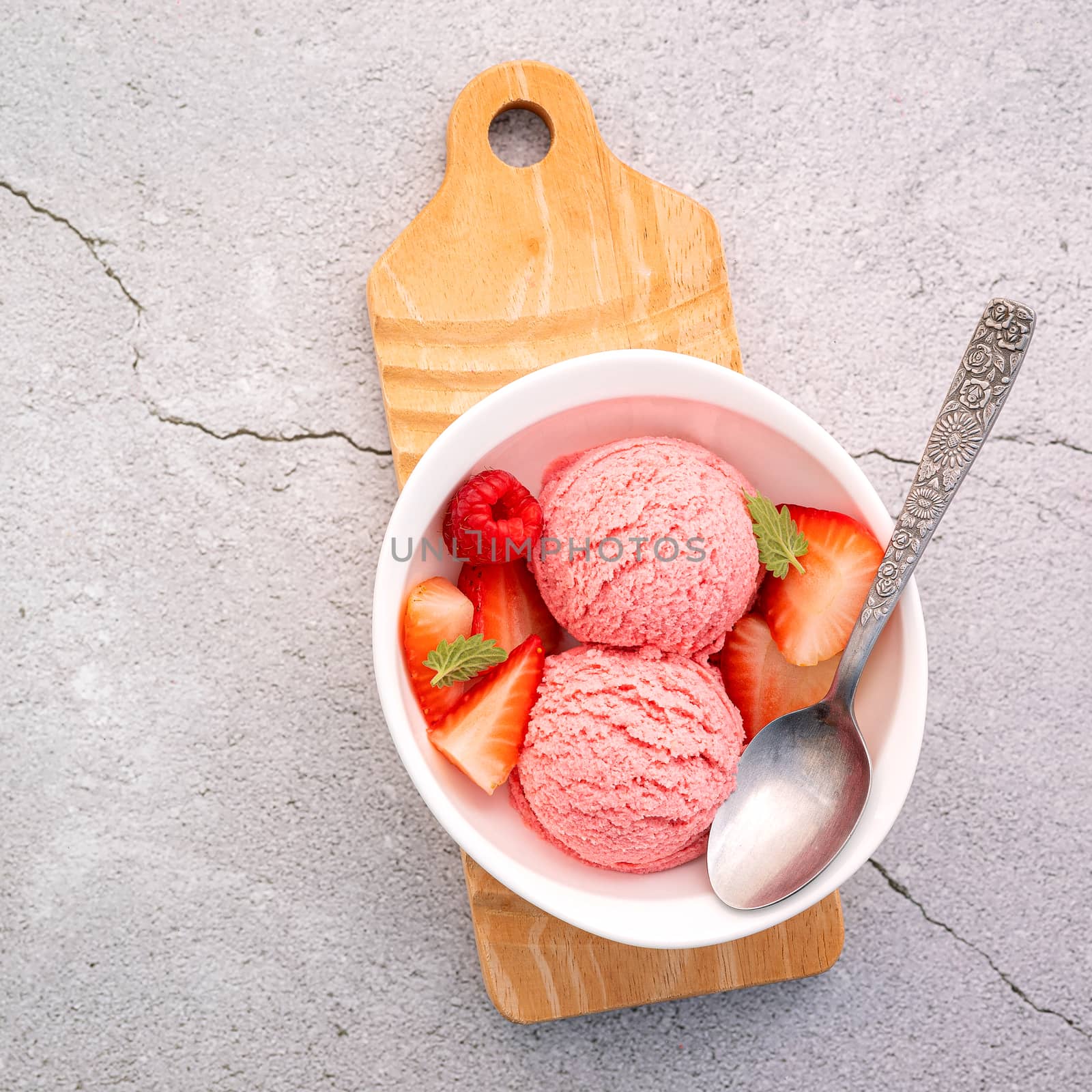 Strawberry  ice cream flavour in white  bowl setup on concrete background . Summer and Sweet menu concept.