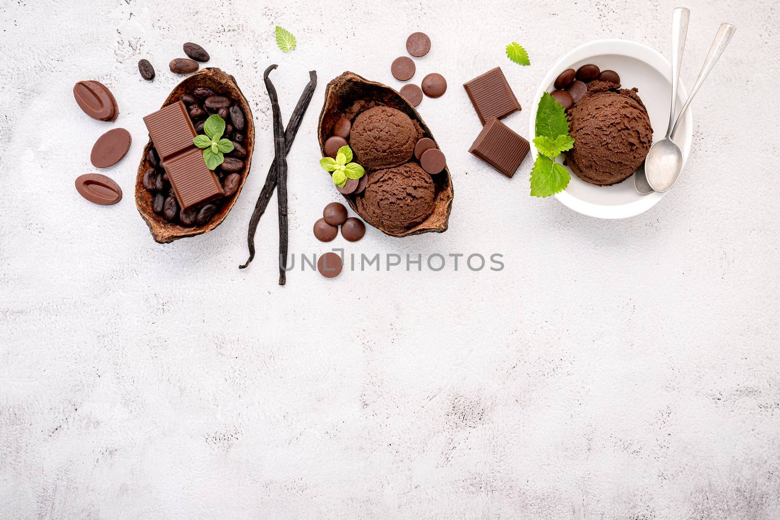 Bowl of chocolate ice cream  flavours with dark chocolate up on white concrete background .