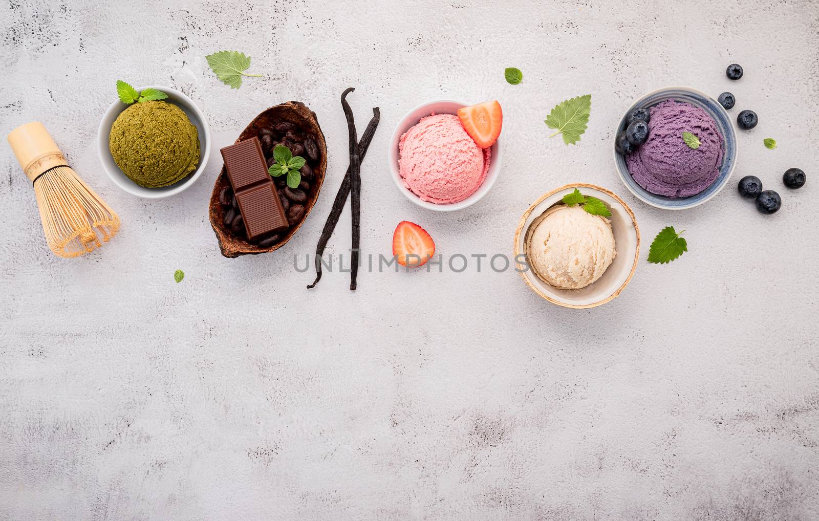 Various of ice cream  flavours in bowl blueberry ,green tea ,coconut ,strawberry and chocolate  setup on white stone background .