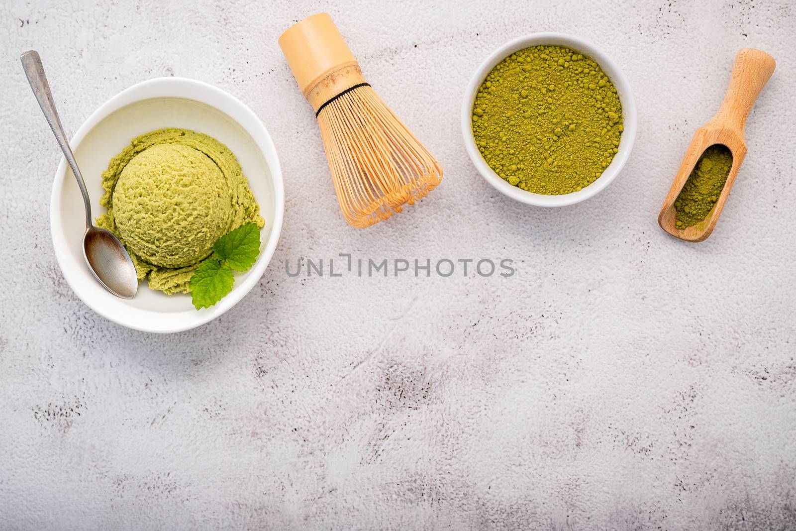 Matcha green tea ice cream with matcha whisk brush  setup on white stone background . Summer and Sweet menu concept.