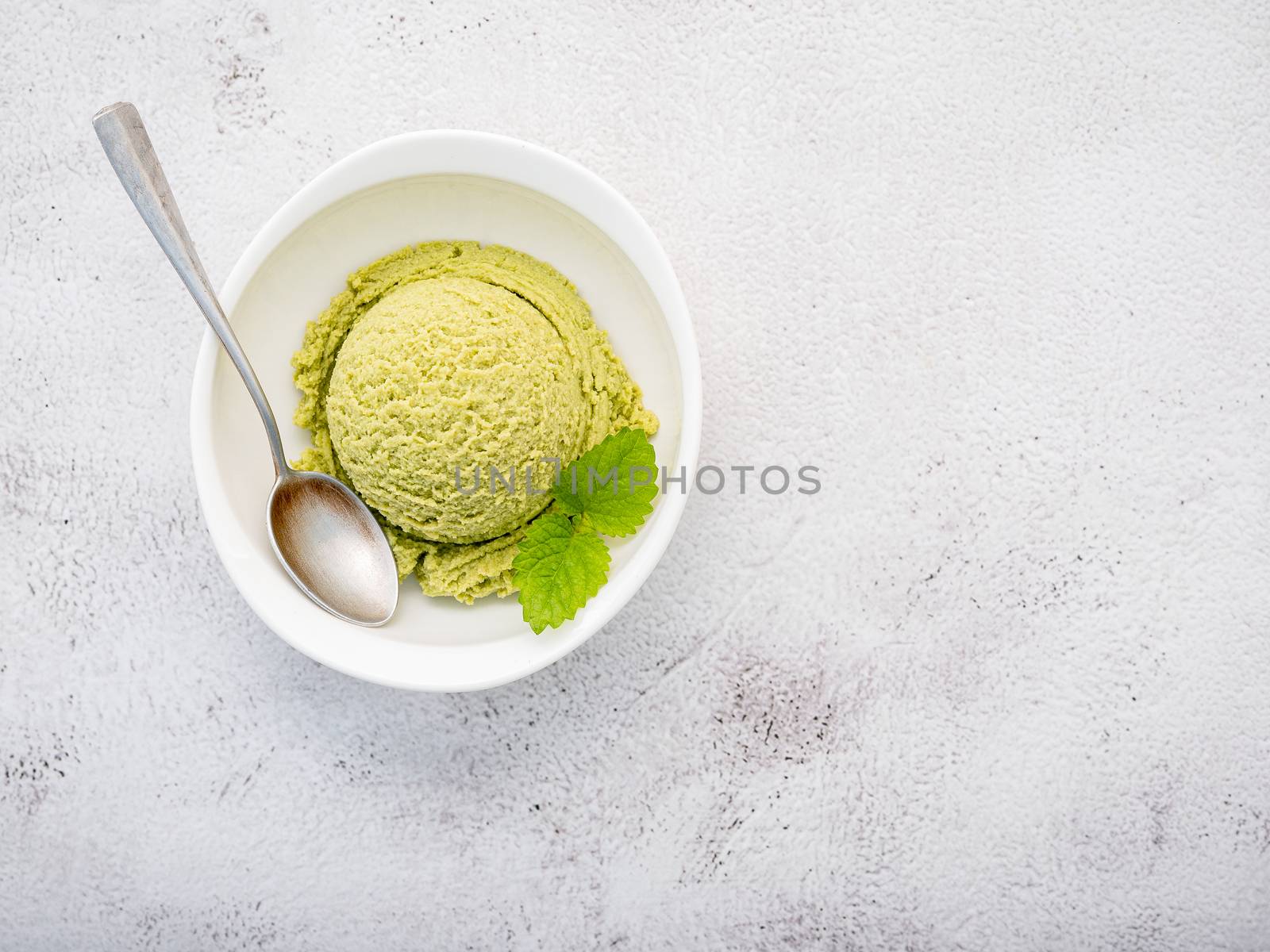 Matcha green tea ice cream with matcha whisk brush  setup on white stone background . Summer and Sweet menu concept.