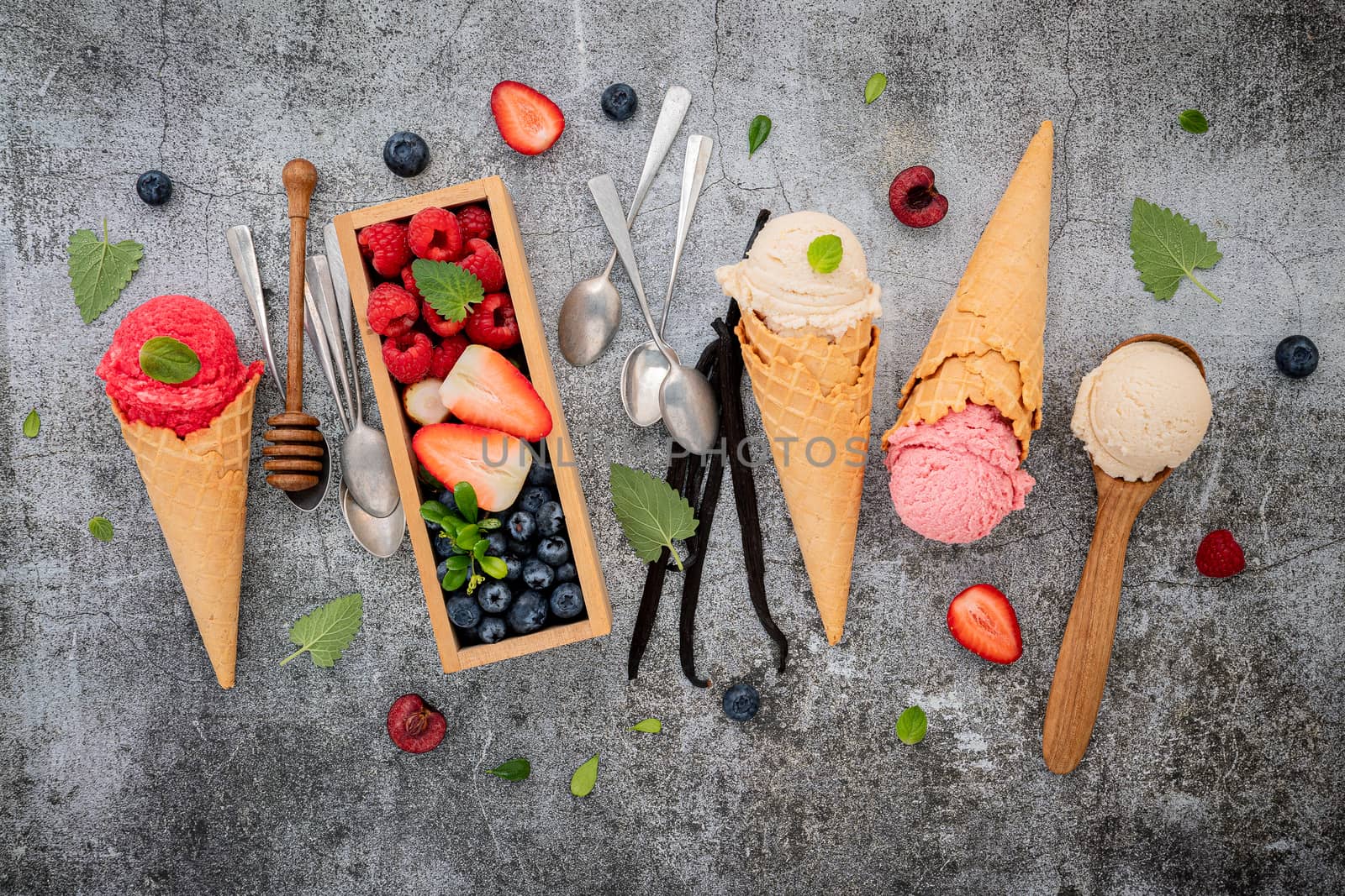 Various of ice cream flavor in cones with berries in wooden box  by kerdkanno