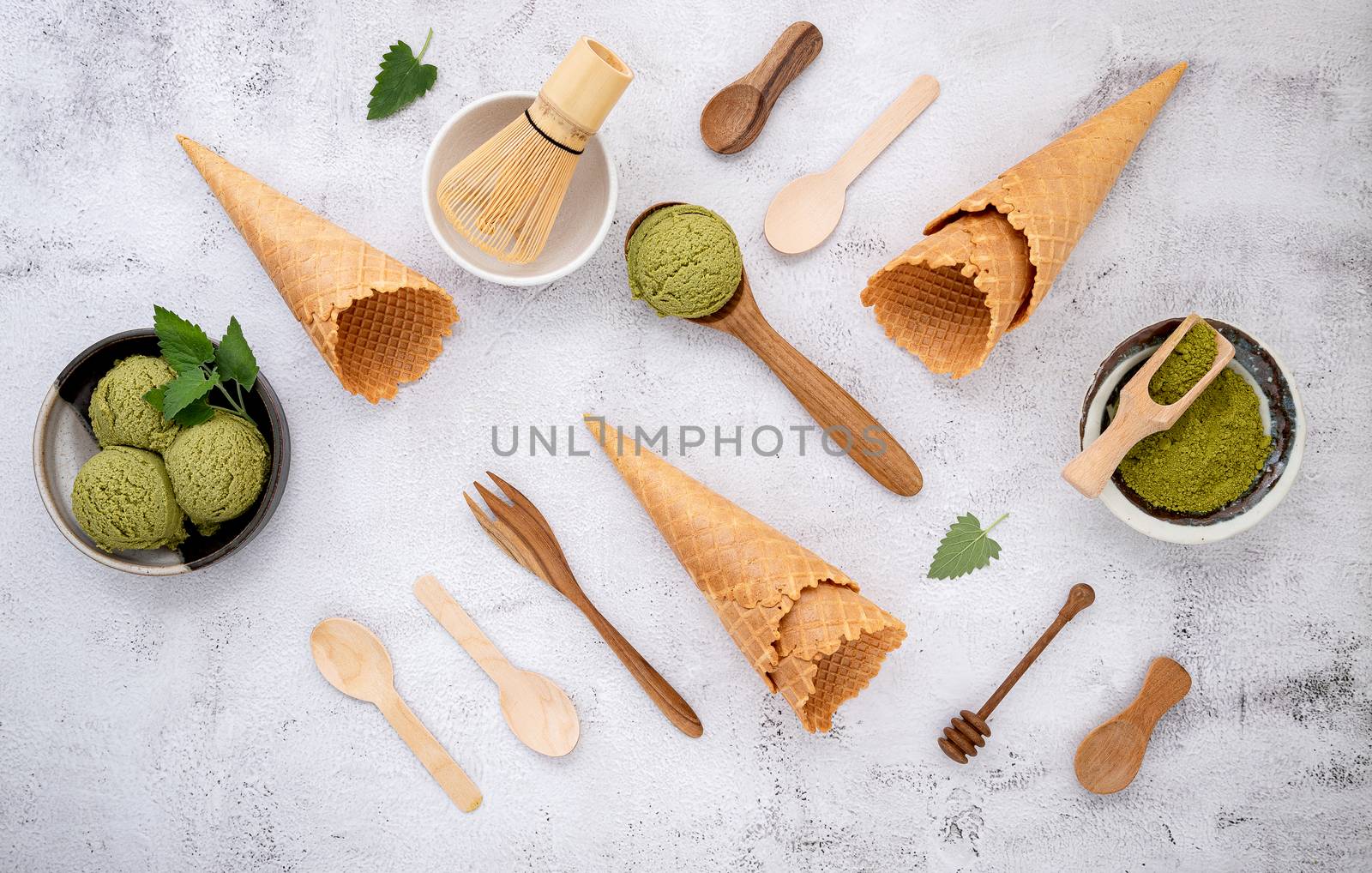 Matcha green tea ice cream with waffle cone and mint leaves  setup on white stone background . Summer and Sweet menu concept.