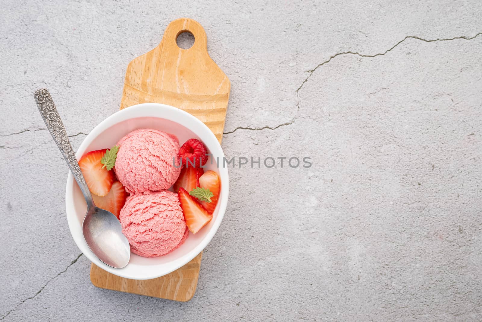 Strawberry  ice cream flavour in white  bowl setup on concrete background . Summer and Sweet menu concept.