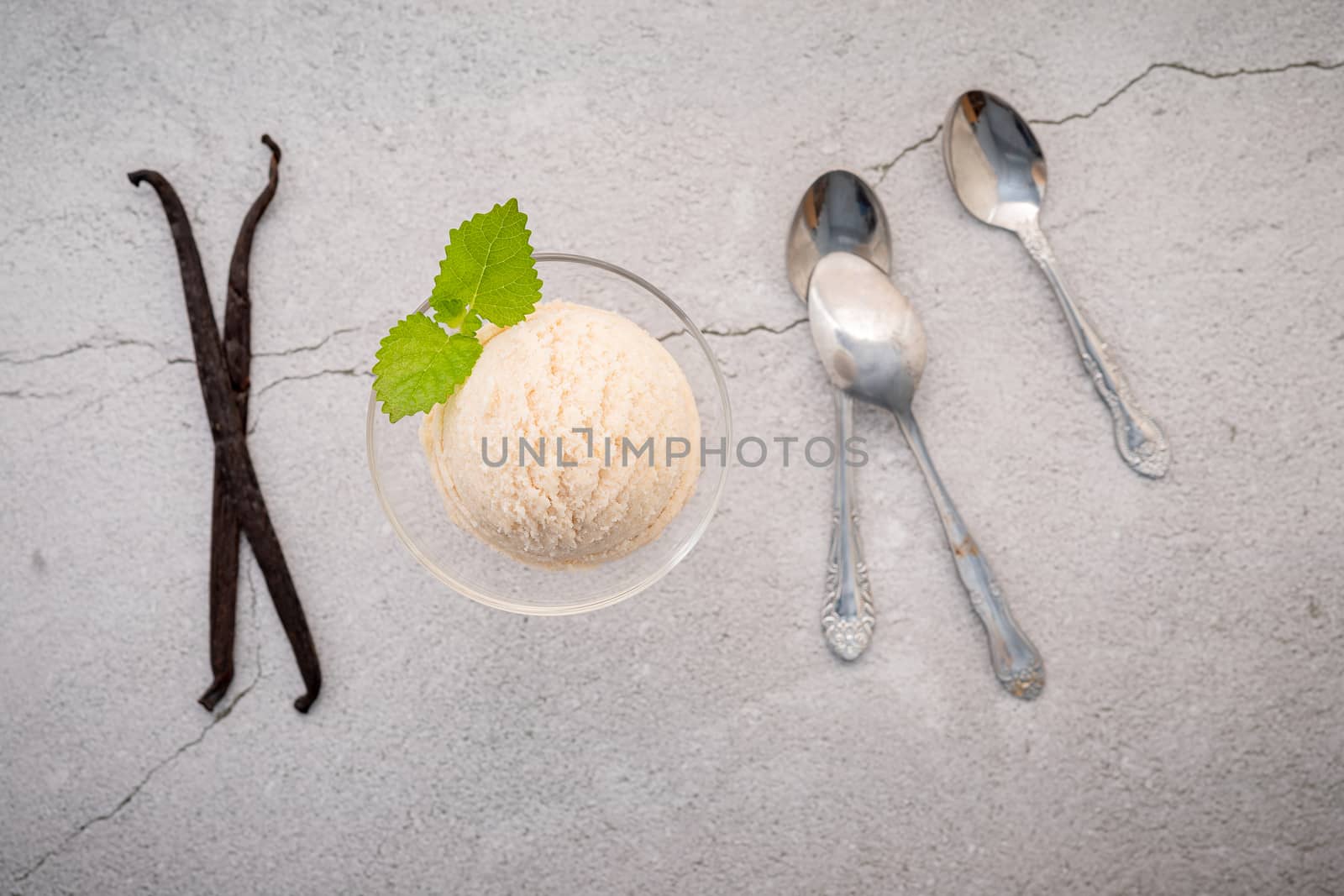 Vanilla ice cream flavor in bowl with vanilla pods setup on concrete background . Summer and Sweet menu concept.