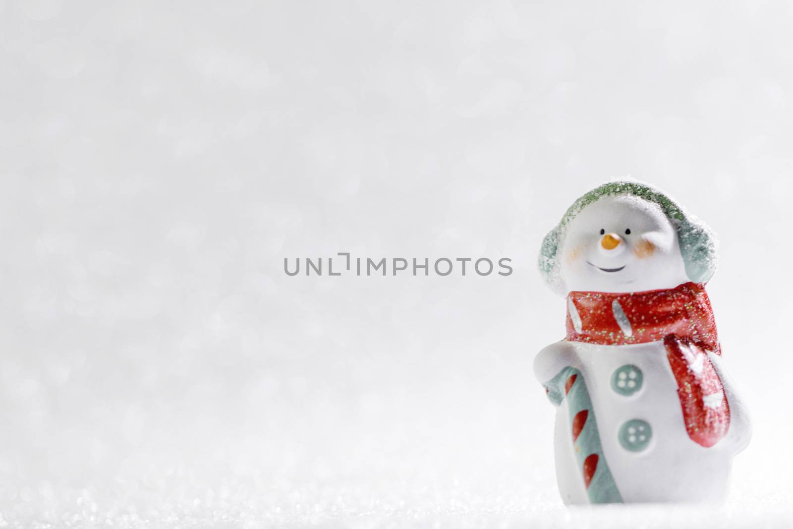 Christmas background of silver bokeh lights with cute toy snowman