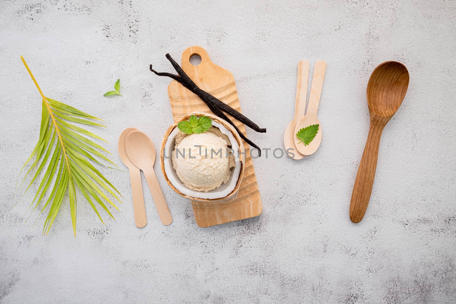 Coconut ice cream flavours in half of coconut setup on white stone background. Summer and Sweet menu concept.