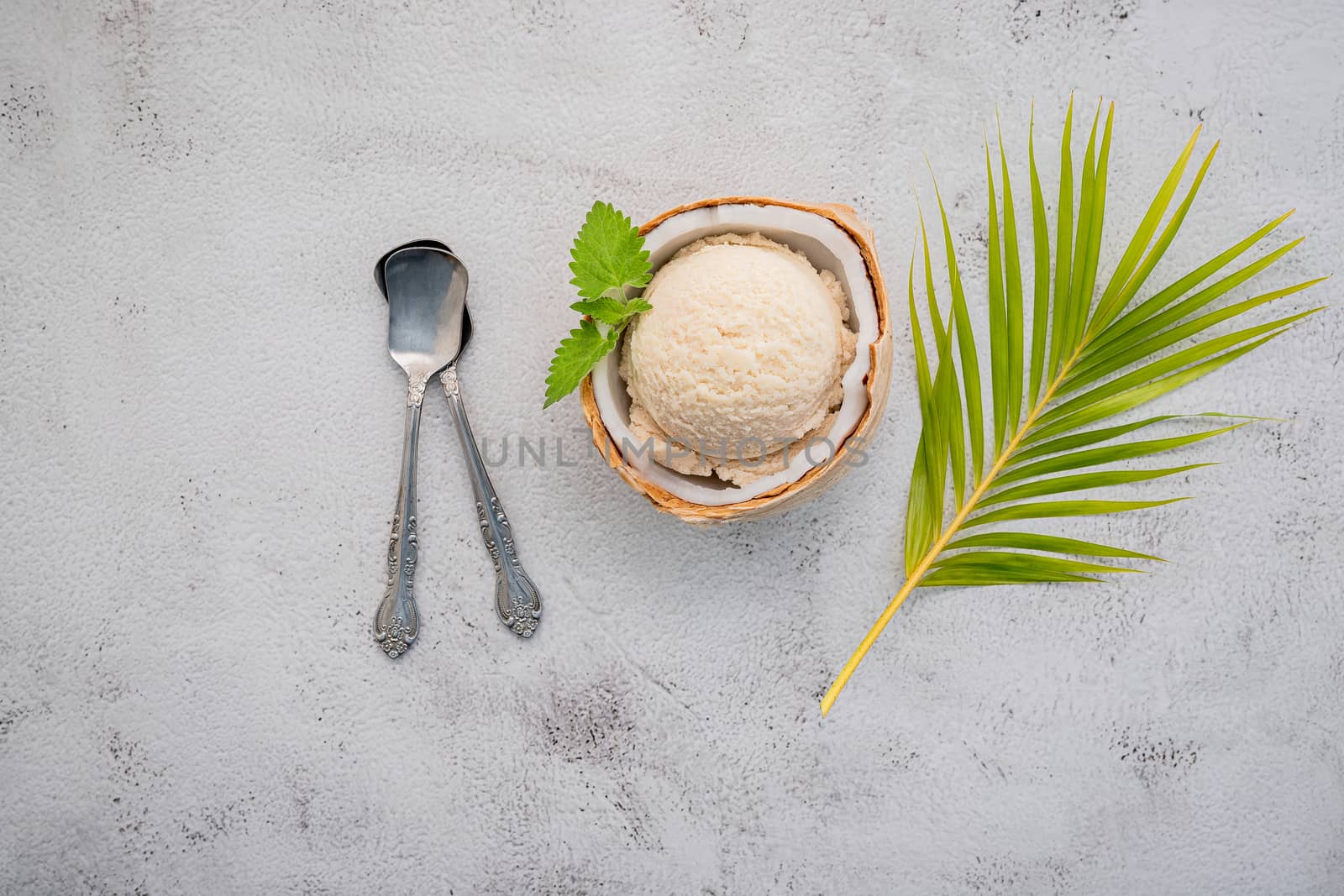 Coconut ice cream flavours in half of coconut setup on white stone background. Summer and Sweet menu concept.