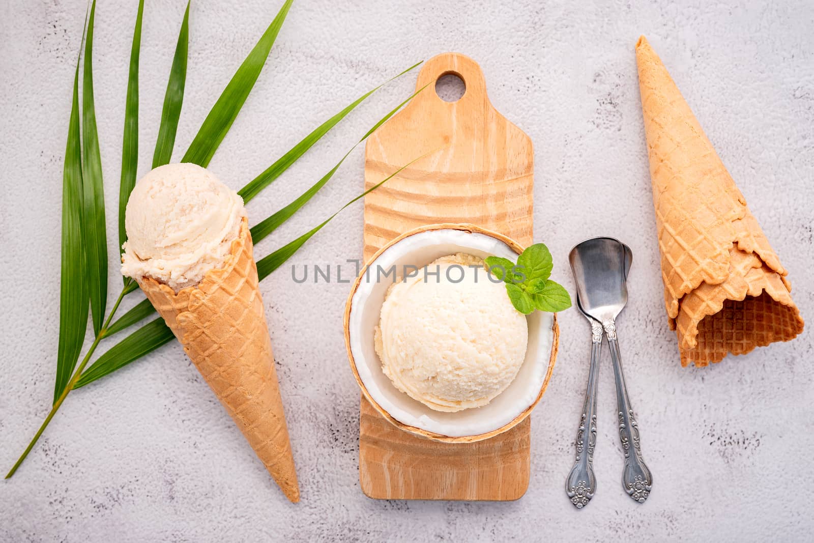 Coconut ice cream flavours in half of coconut setup on white stone background. Summer and Sweet menu concept.