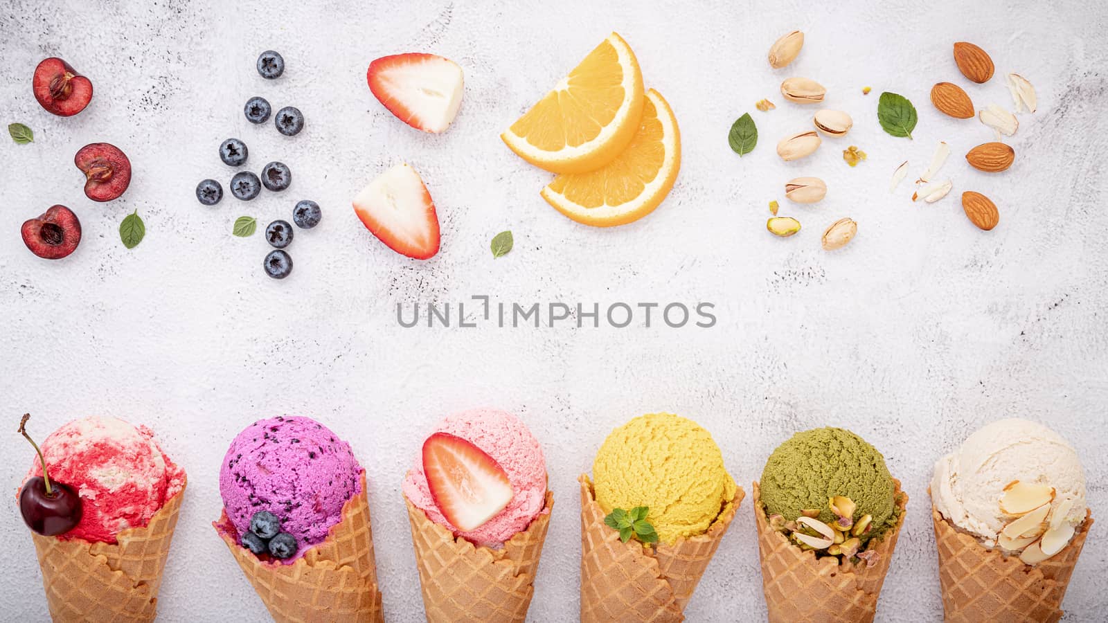 Various of ice cream flavor in cones blueberry ,pistachio ,almond ,orange and cherry setup on white stone background . Summer and Sweet menu concept.