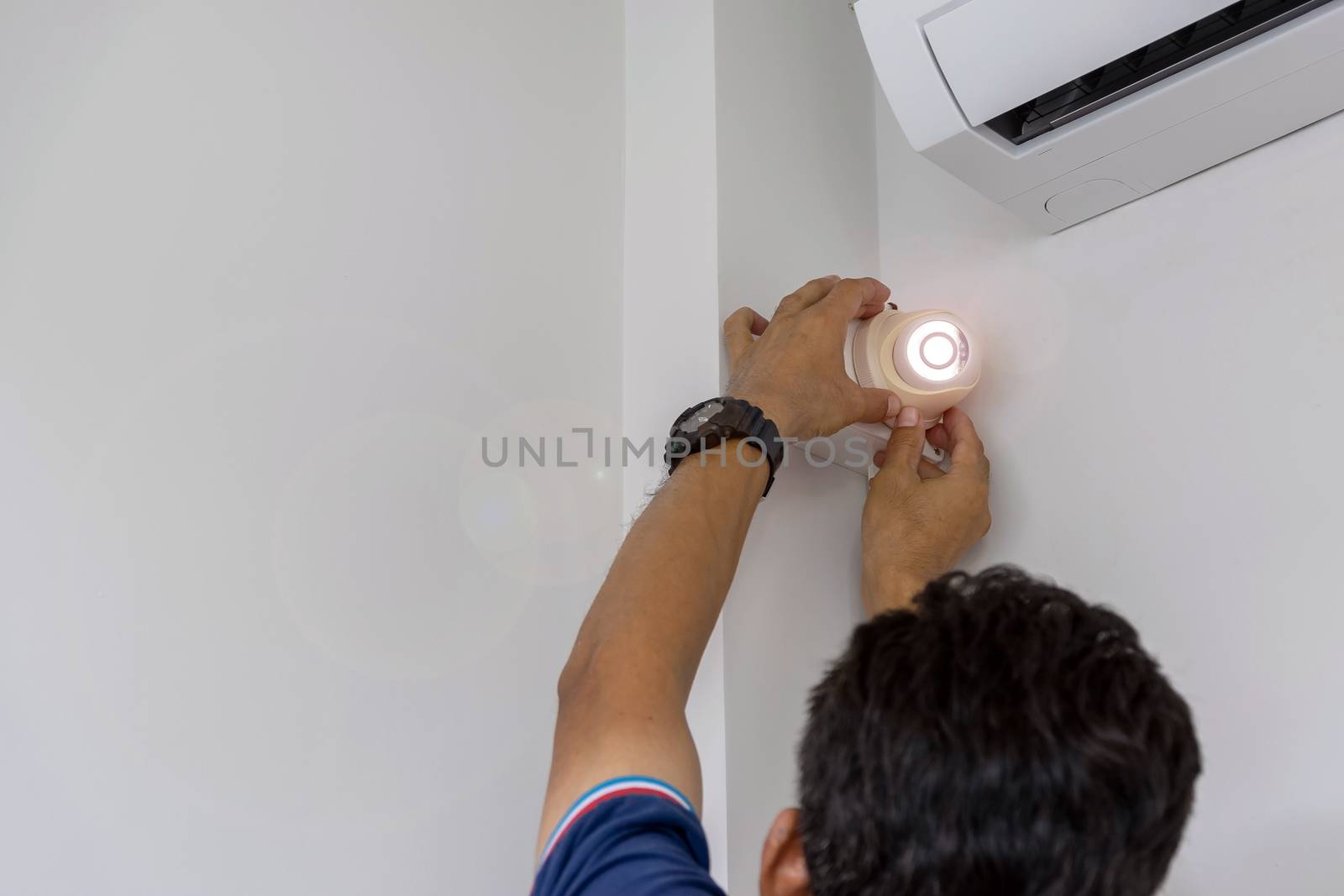 Technicians are installing a CCTV camera on the wall, can connect to the Internet, and control the camera via a smart phone or tablet.
